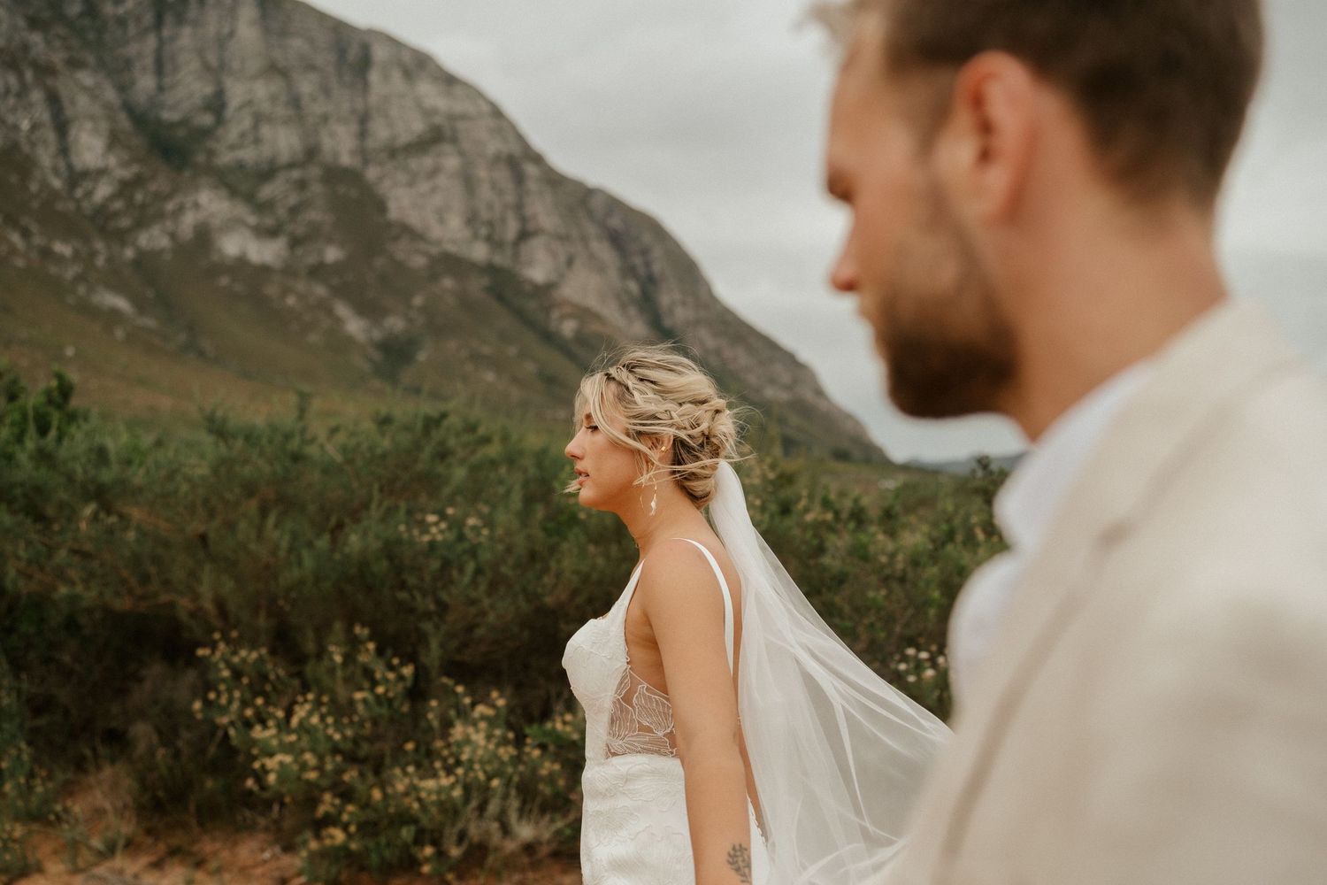 A candid wedding photo with majestic mountains creating a dramatic natural backdrop.