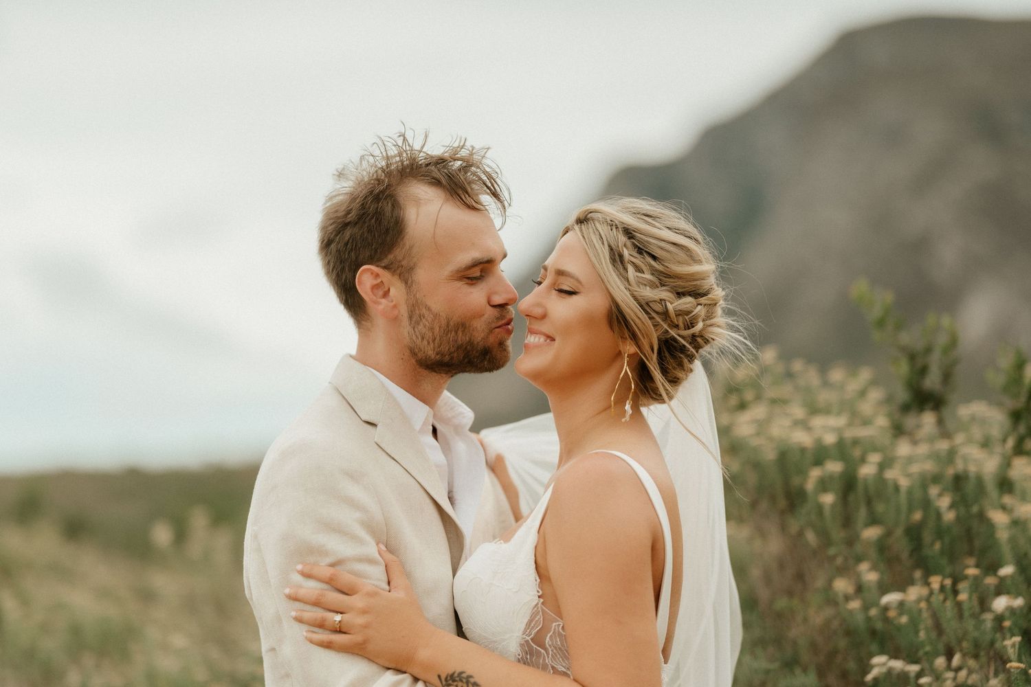 An intimate wedding portrait captured against a scenic mountain landscape.