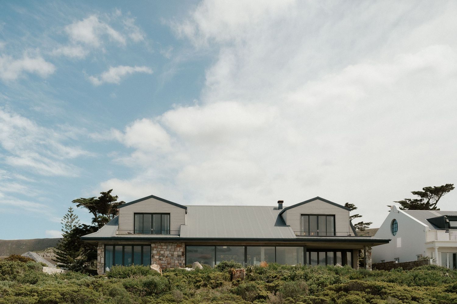 Contemporary coastal home with wrap-around porch and mountain views.