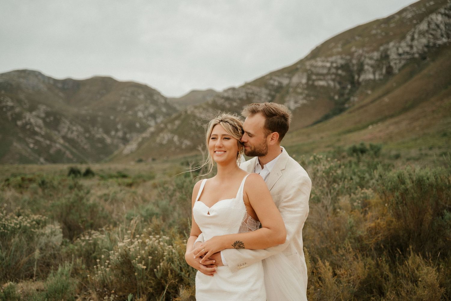 Romantic mountain landscape serves as backdrop for intimate embrace.