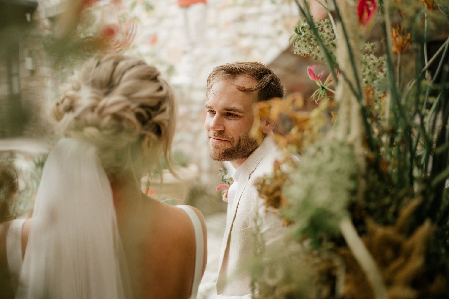 An intimate wedding moment captured in soft lighting with floral decor.