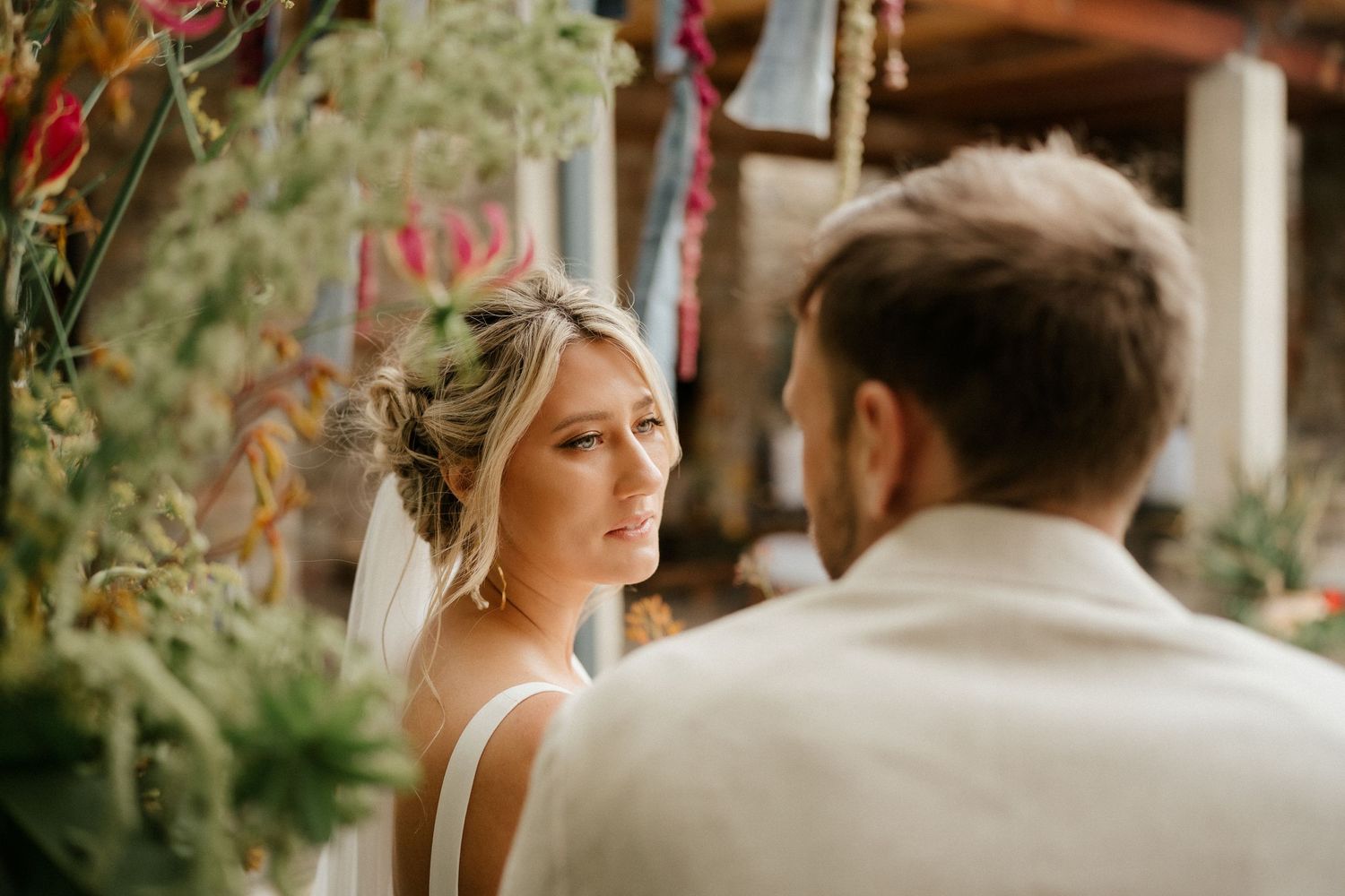 Sun-lit outdoor wedding scene with floral decor and soft natural lighting.