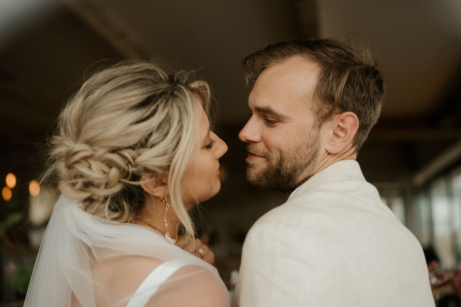 A romantic moment captured between newlyweds in an intimate indoor setting.