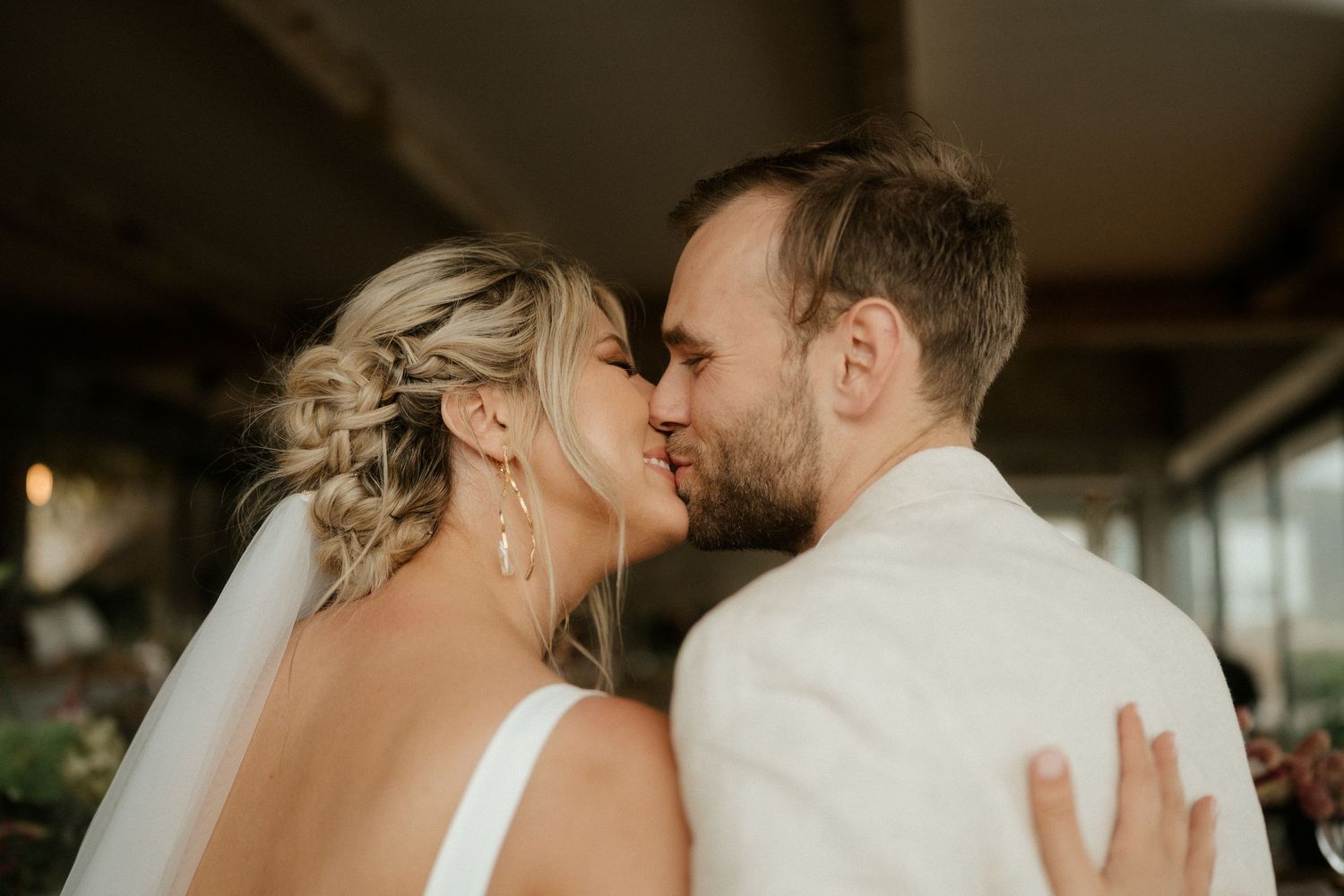 An intimate wedding moment shared under natural window lighting.
