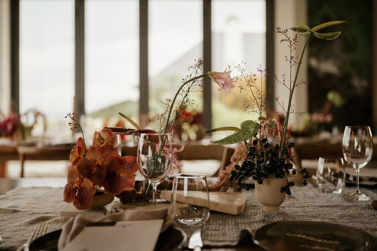 Elegant table setting with floral centerpieces and wine glasses for wedding reception.