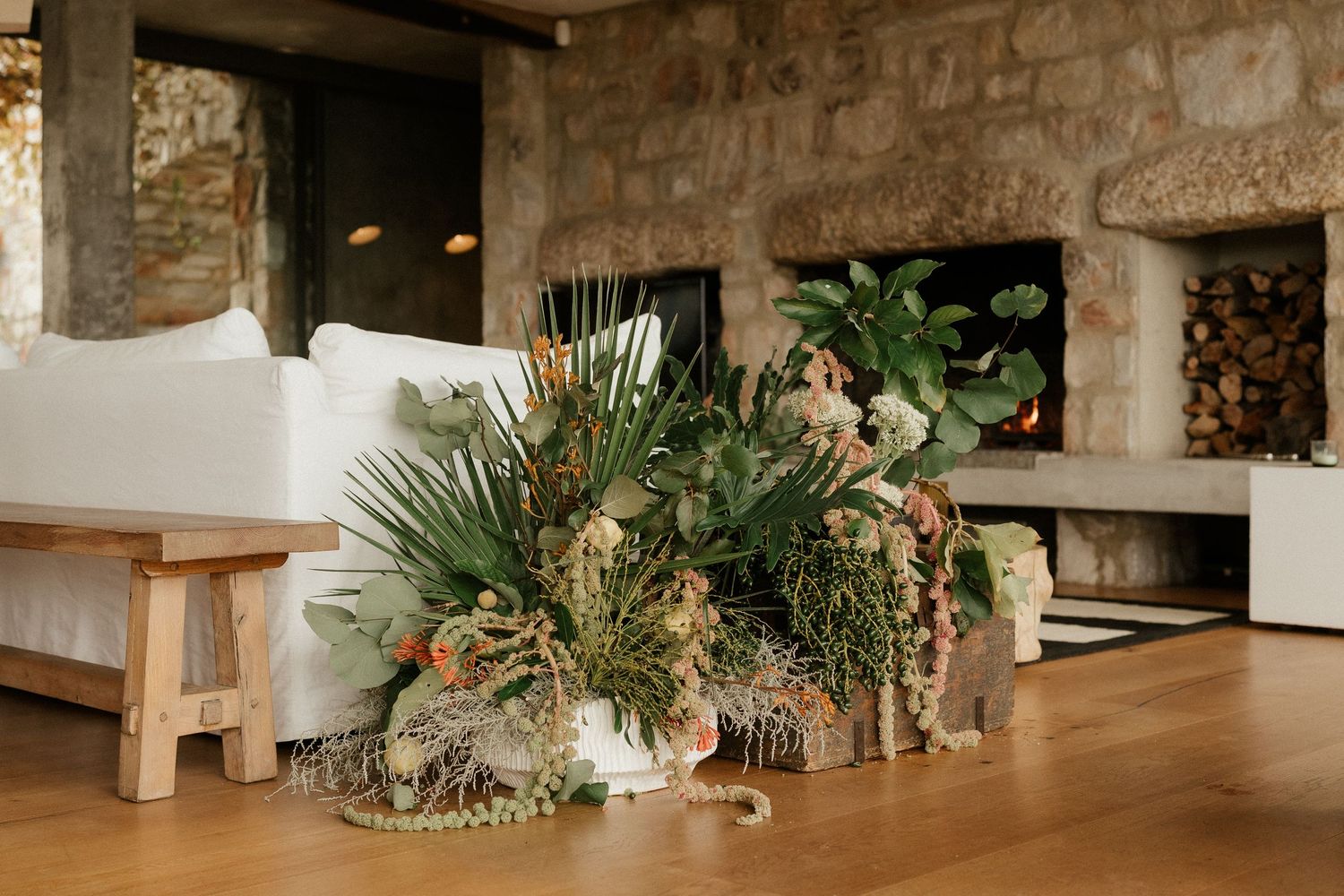 Modern rustic floral arrangement with dried elements on wooden table.