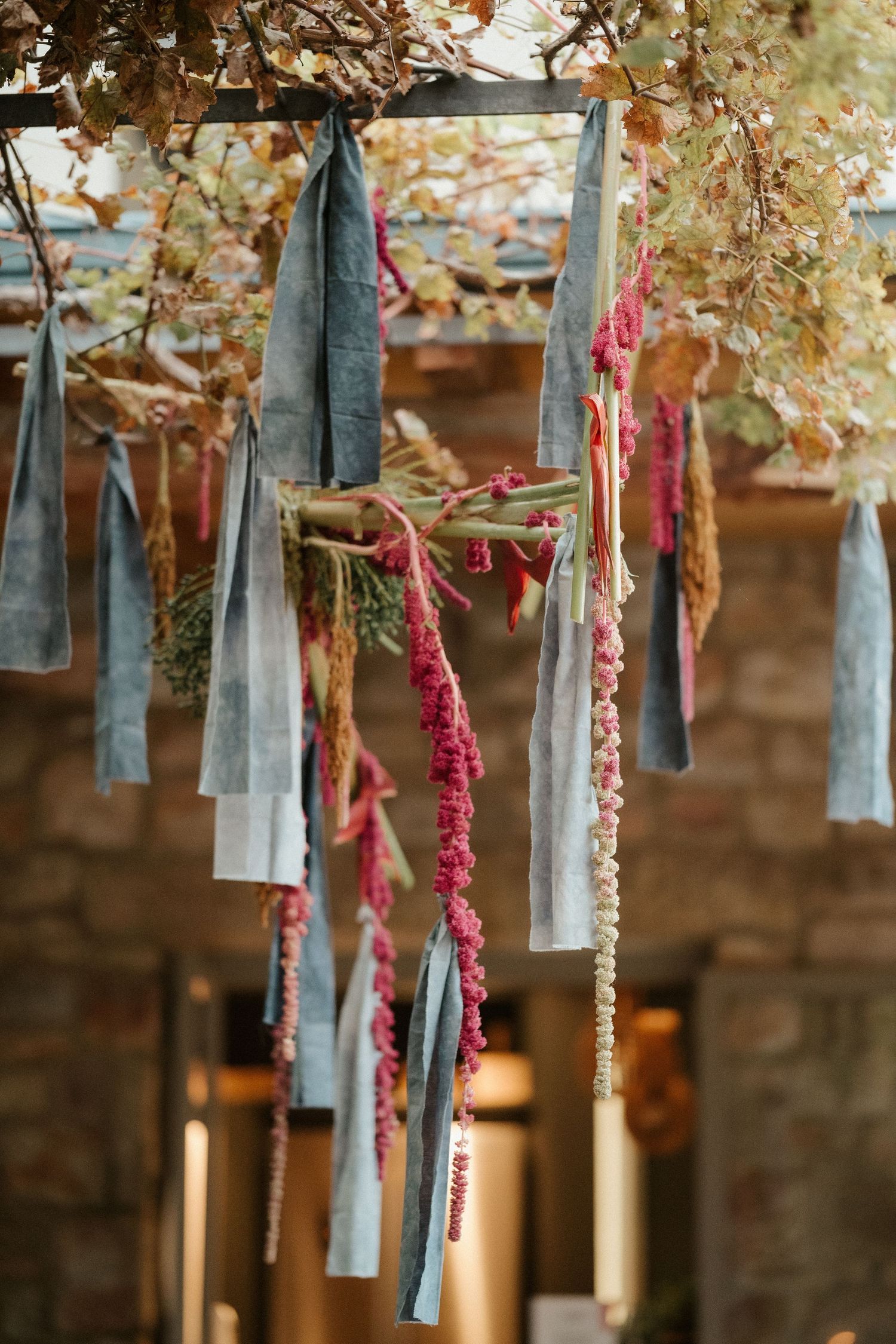 Blue ribbons and pink floral decorations hang from branches creating a whimsical outdoor display.