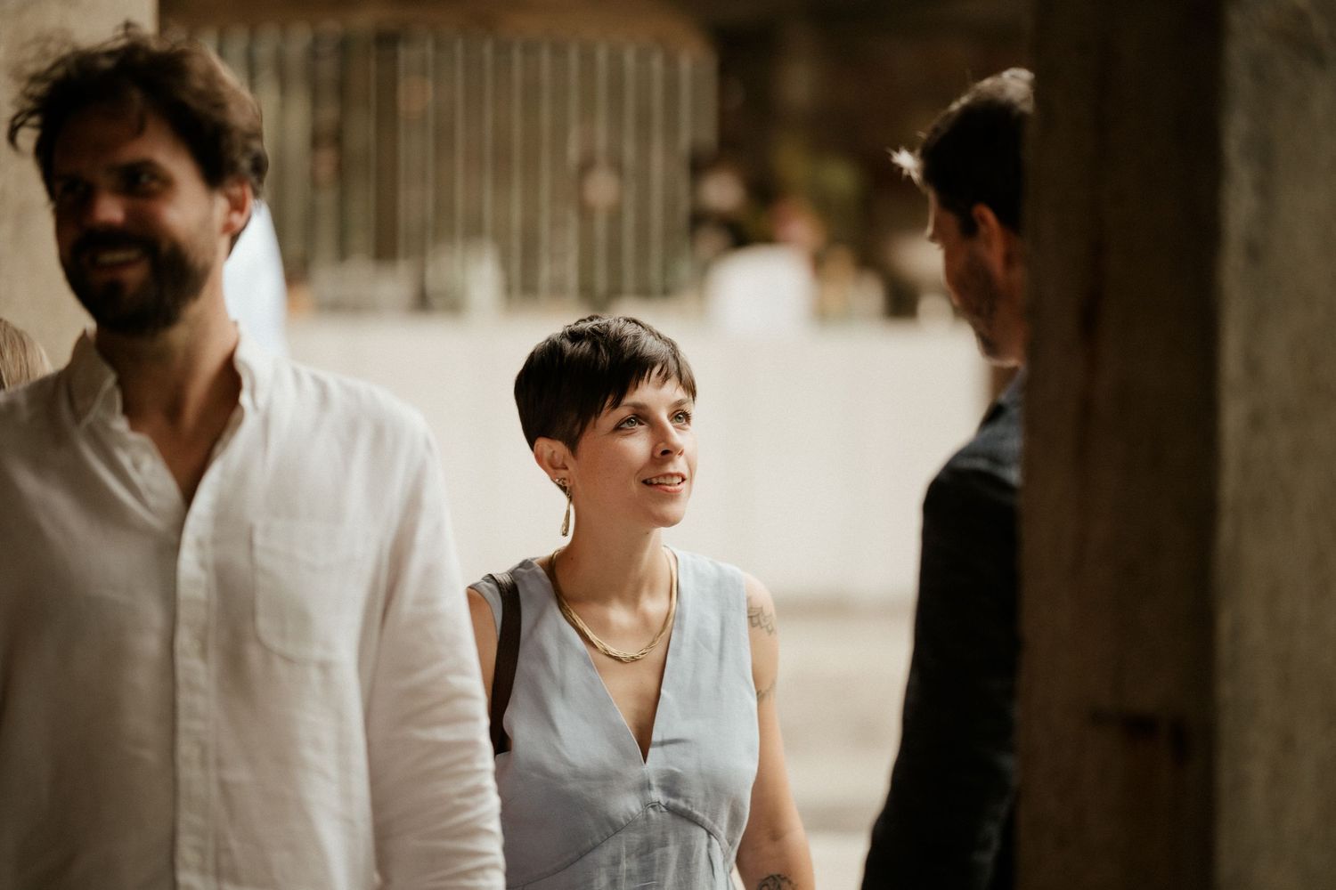 People share a candid outdoor moment wearing casual attire in warm natural lighting.