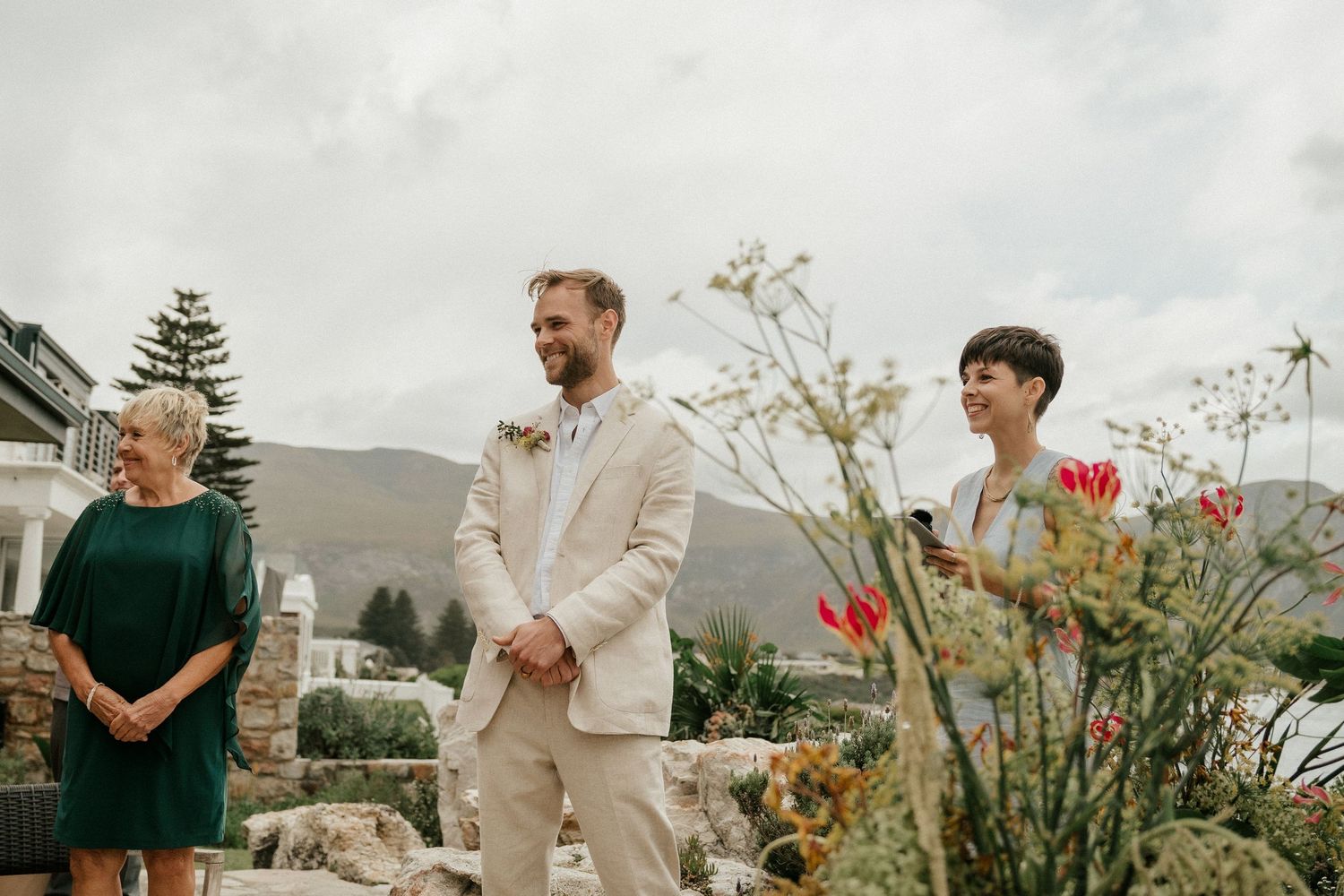 Outdoor wedding ceremony with scenic mountain views and wildflowers in the background.