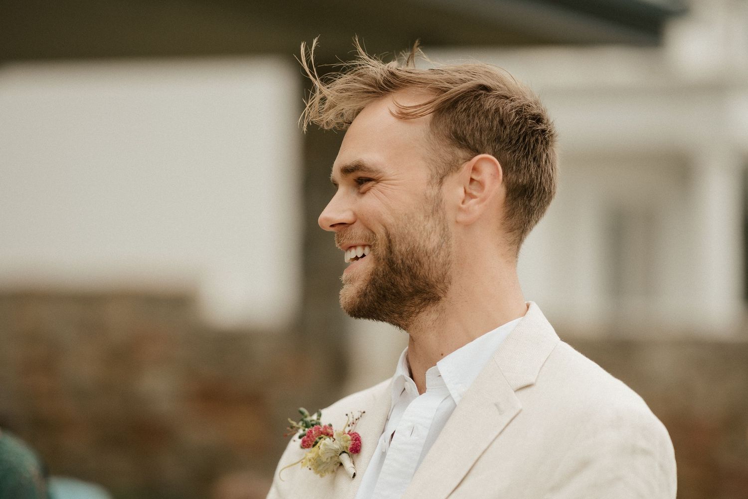 Side profile portrait against blurred stone building background.