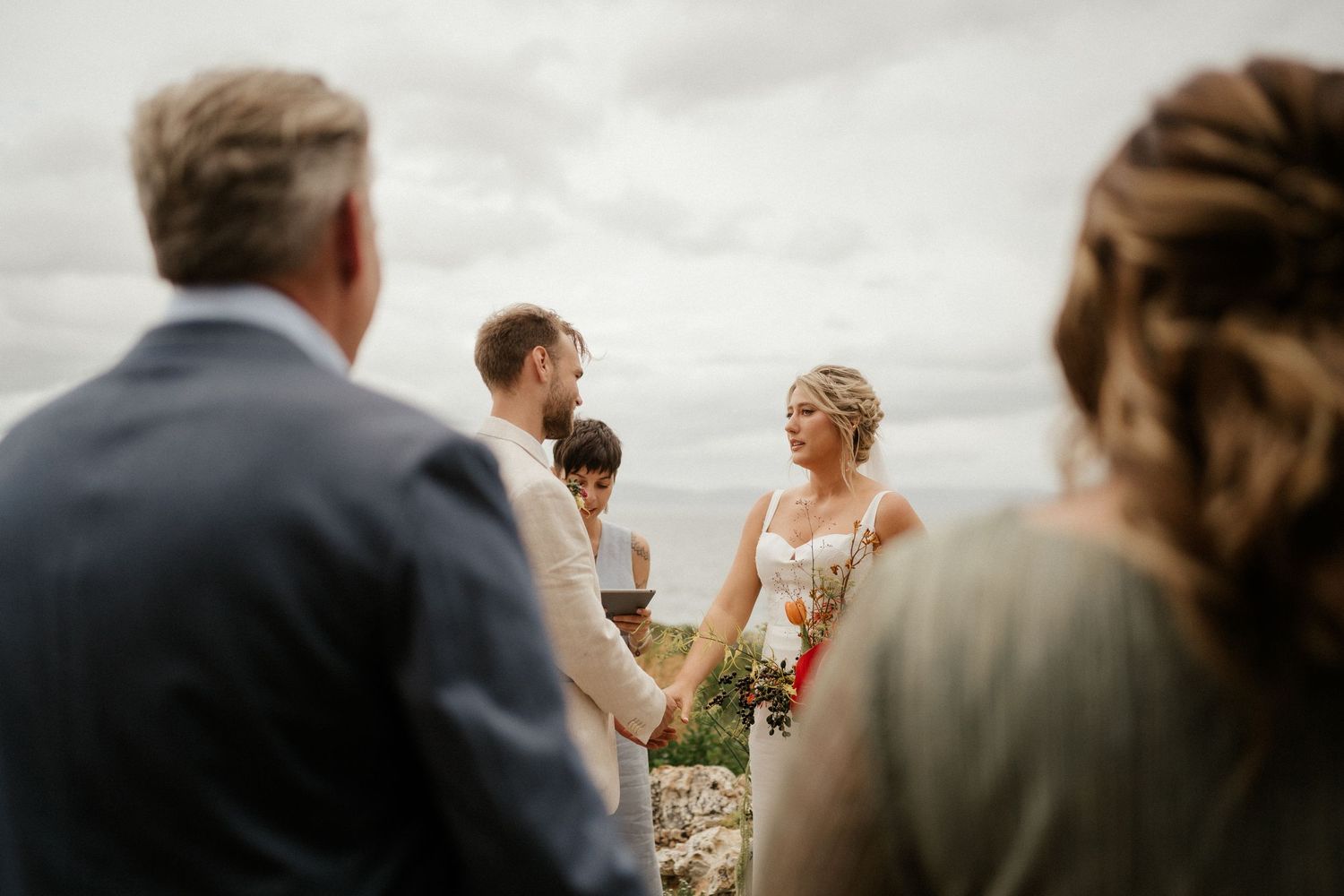An outdoor wedding ceremony taking place under cloudy skies.