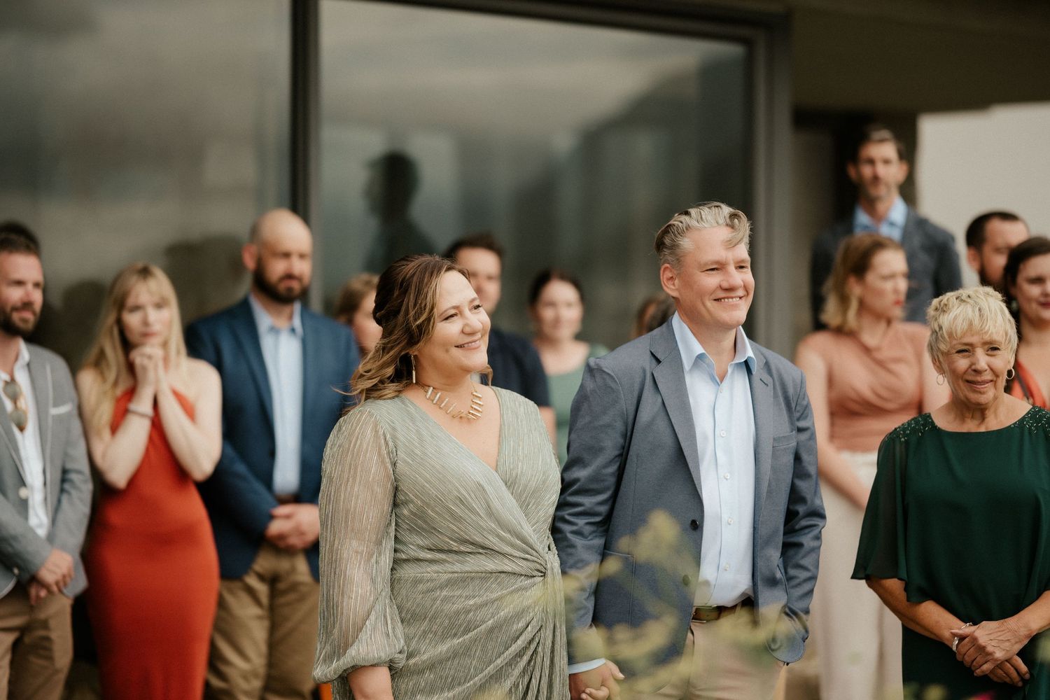 A group of wedding guests gathered outdoors for a celebration event.