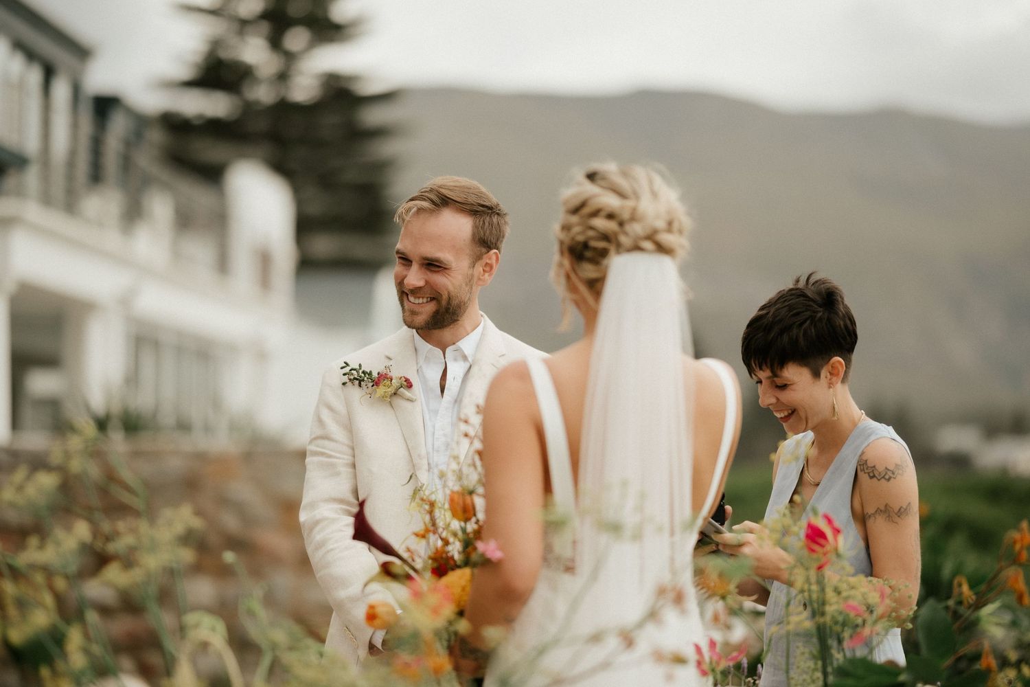 An intimate outdoor wedding ceremony moment with mountain scenery in the background.