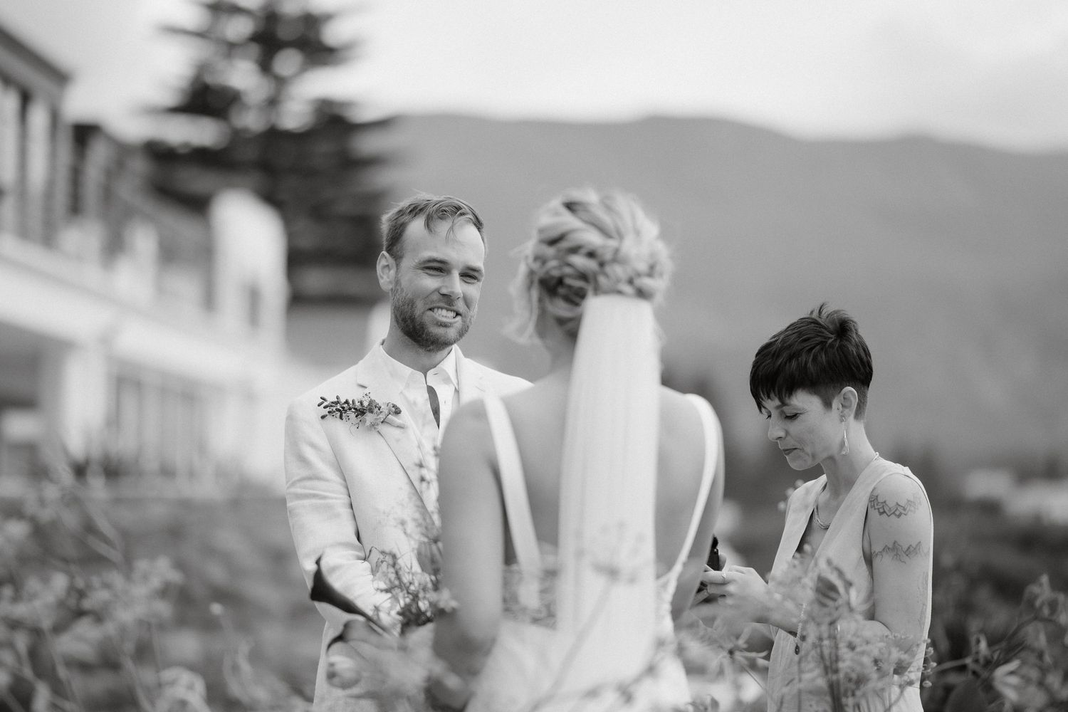 An intimate outdoor wedding ceremony moment against a mountain backdrop.