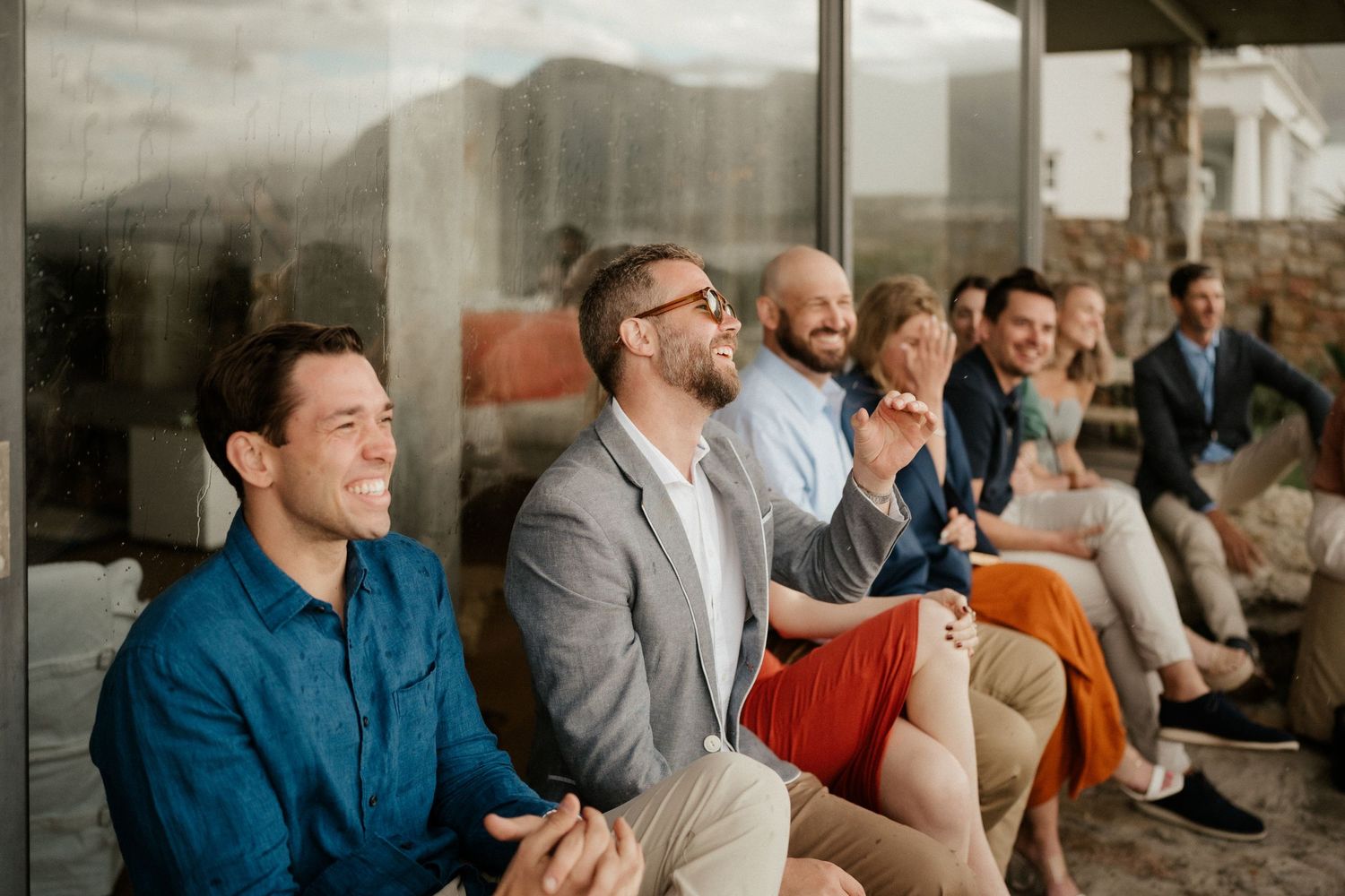 Group of guests sitting and laughing together during an event presentation or talk.