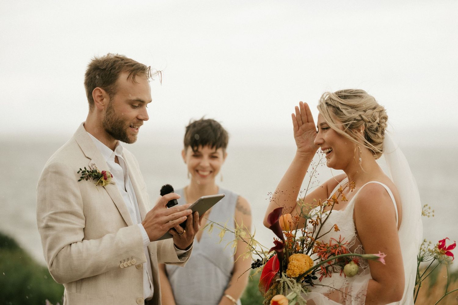 Wedding ceremony on a hilltop with the couple and officiant sharing emotional vows and exchanging rings.