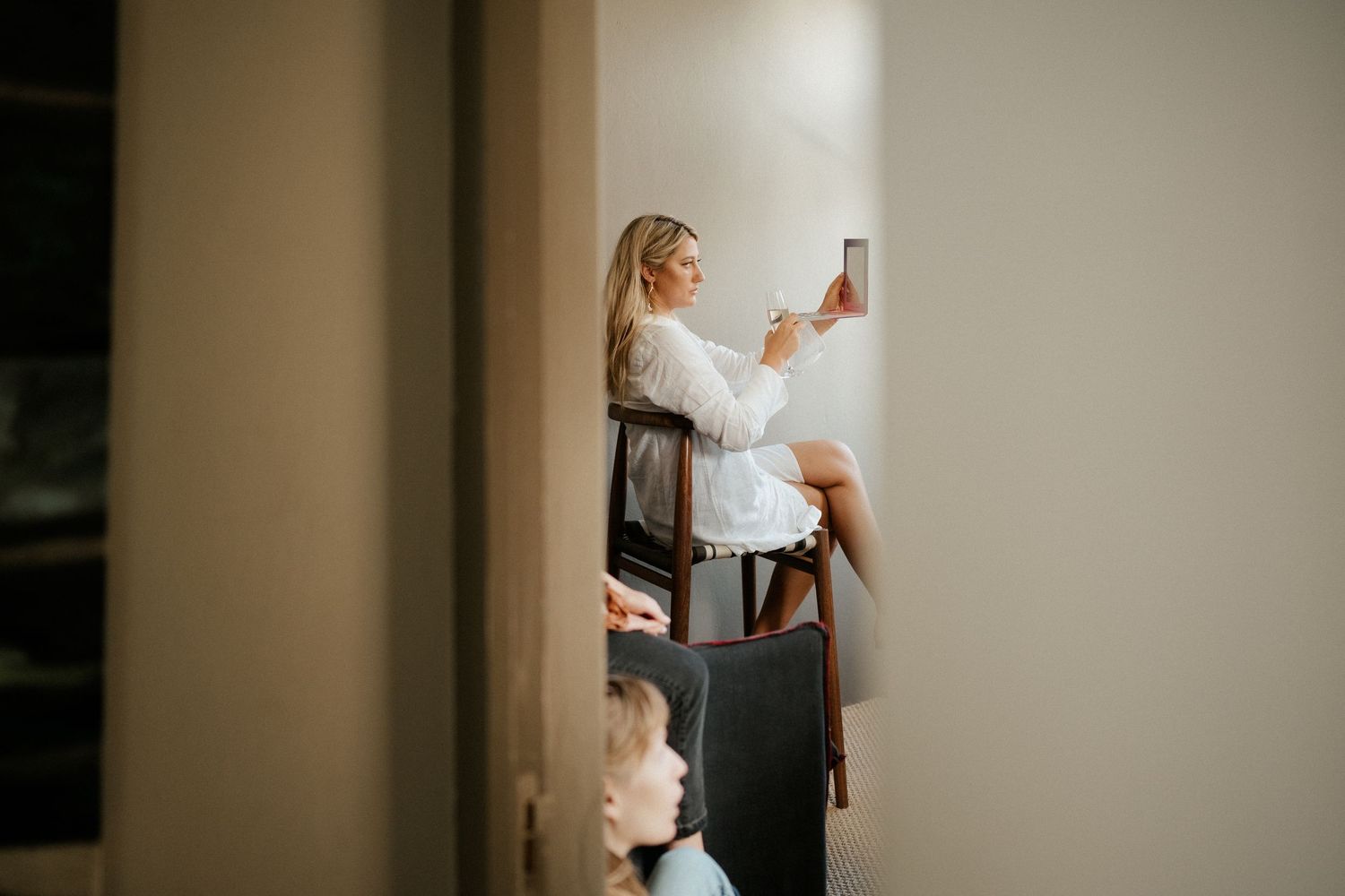 Candid wedding preparation moment captured through a doorway showing bridal preparations.