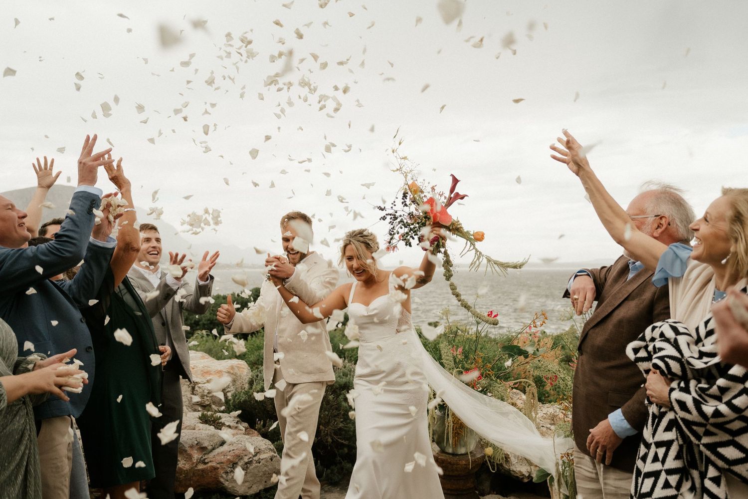 Wedding celebration with confetti being thrown in the air during an outdoor ceremony.