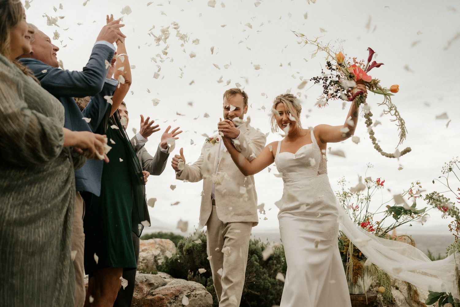 Joyful celebration with confetti toss at outdoor mountain wedding.
