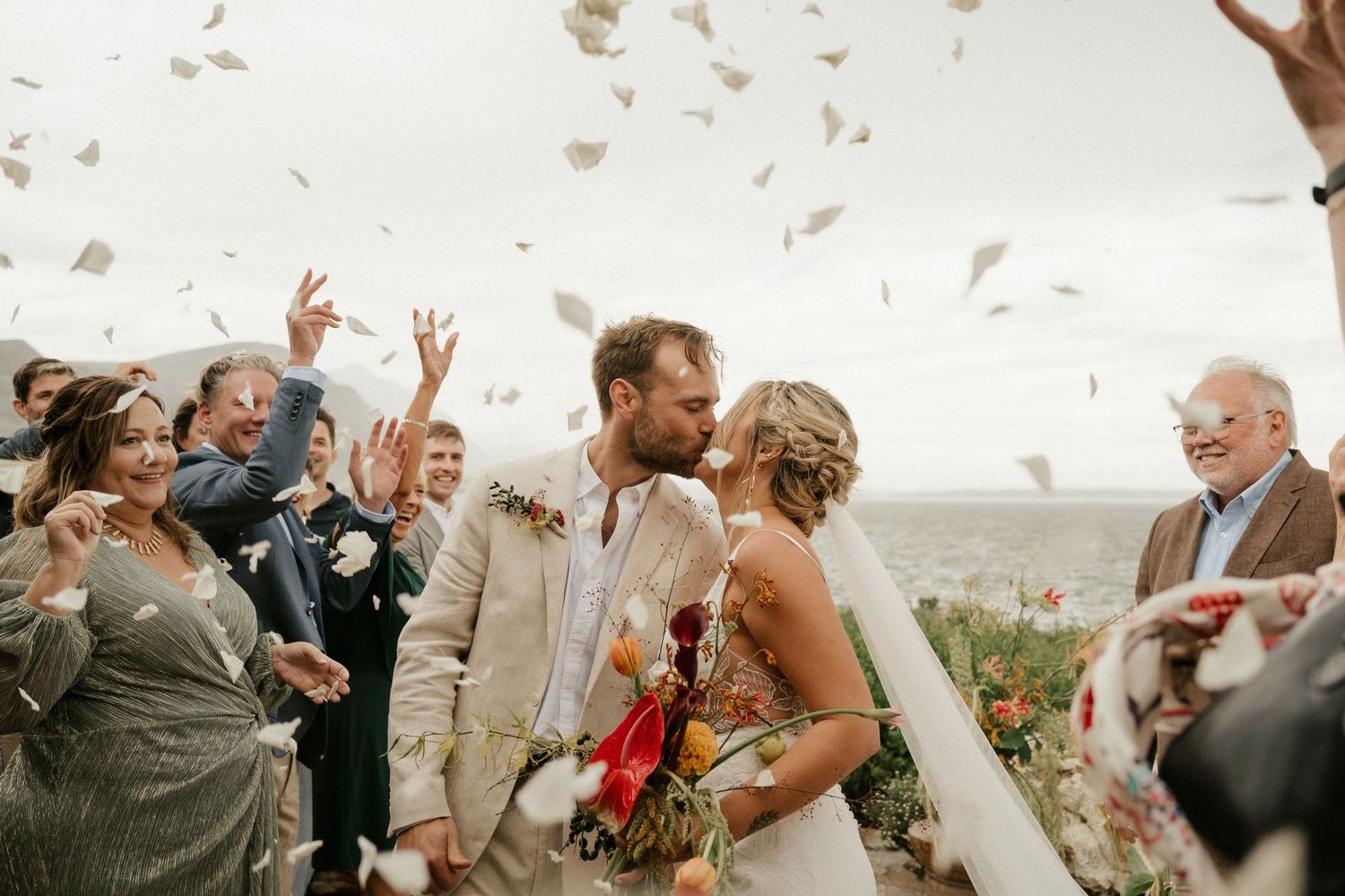 Wedding celebration moment with confetti flying through the air during an outdoor ceremony.