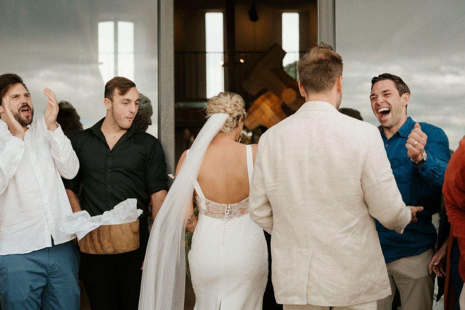 Wedding guests laugh and celebrate joyfully during a candid moment at the reception.