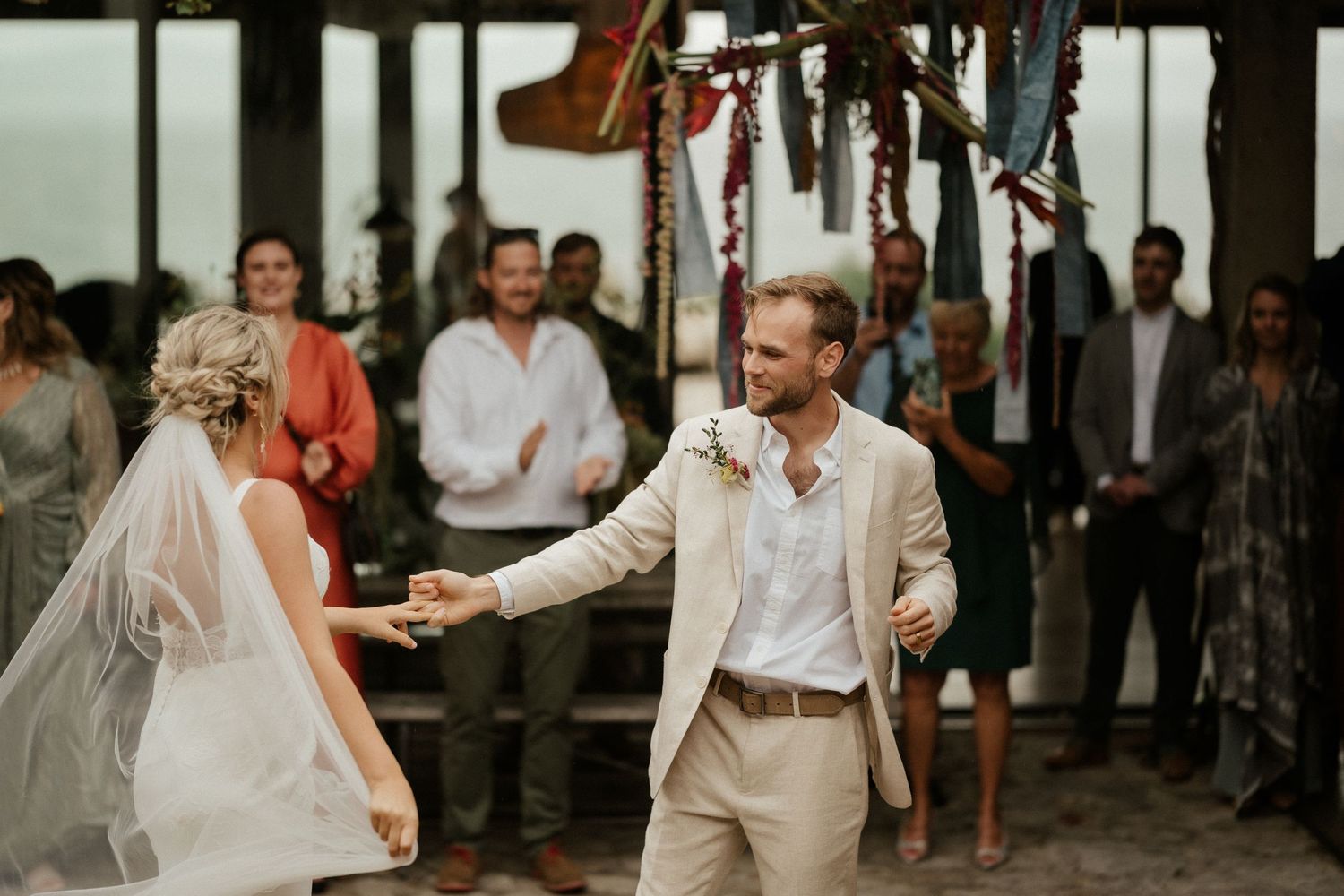 A couple shares their first dance at a rustic outdoor wedding reception.