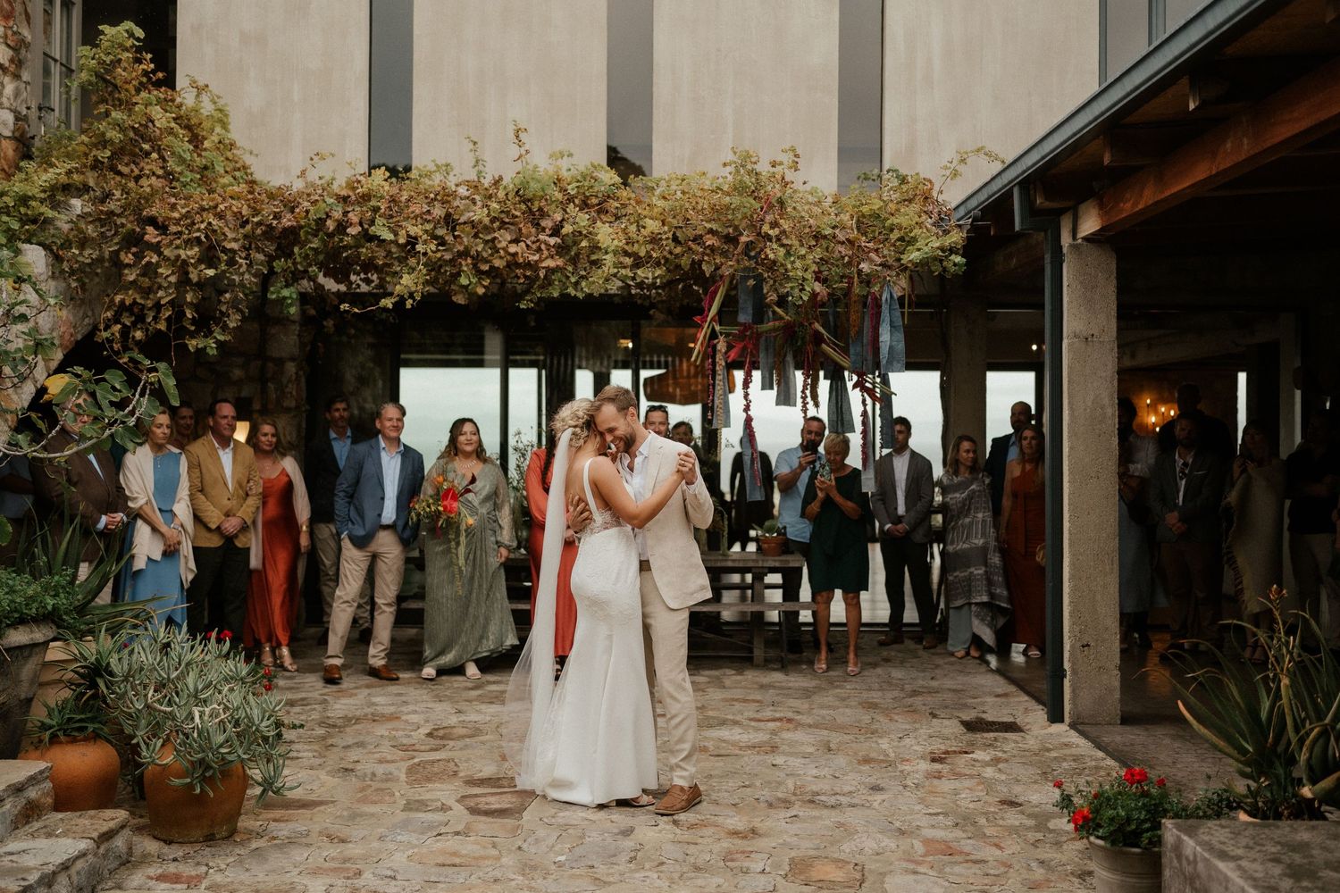 A couple embraces during their wedding reception in a beautifully decorated outdoor venue.