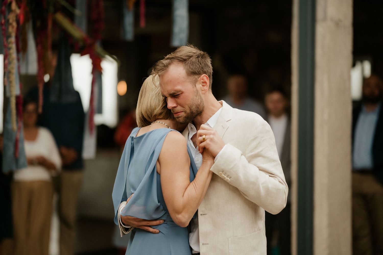 An intimate dance moment at an indoor wedding reception with soft lighting.