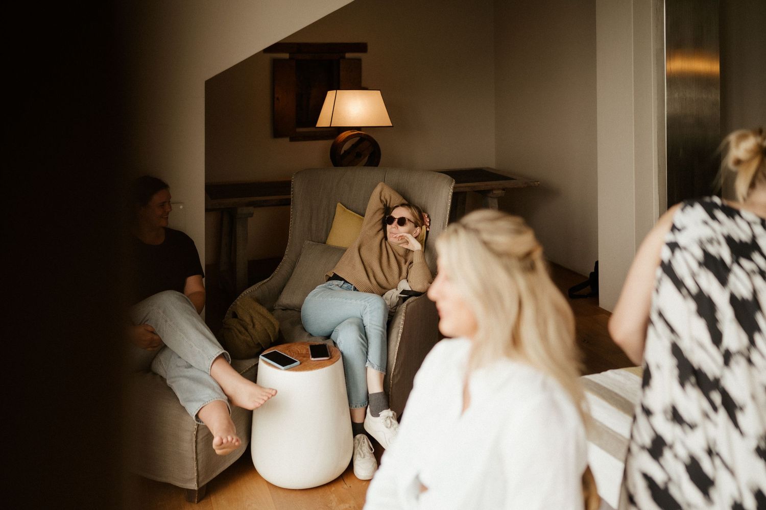 People gather in a cozy living room with warm lighting and modern decor during an intimate indoor gathering.