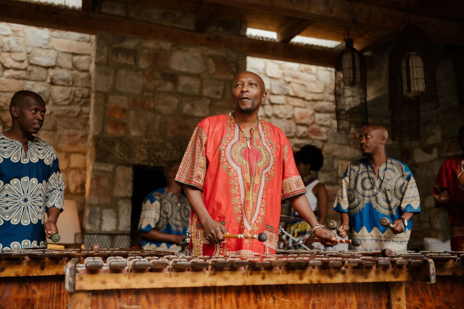 Musicians perform at traditional wooden xylophone during cultural celebration.