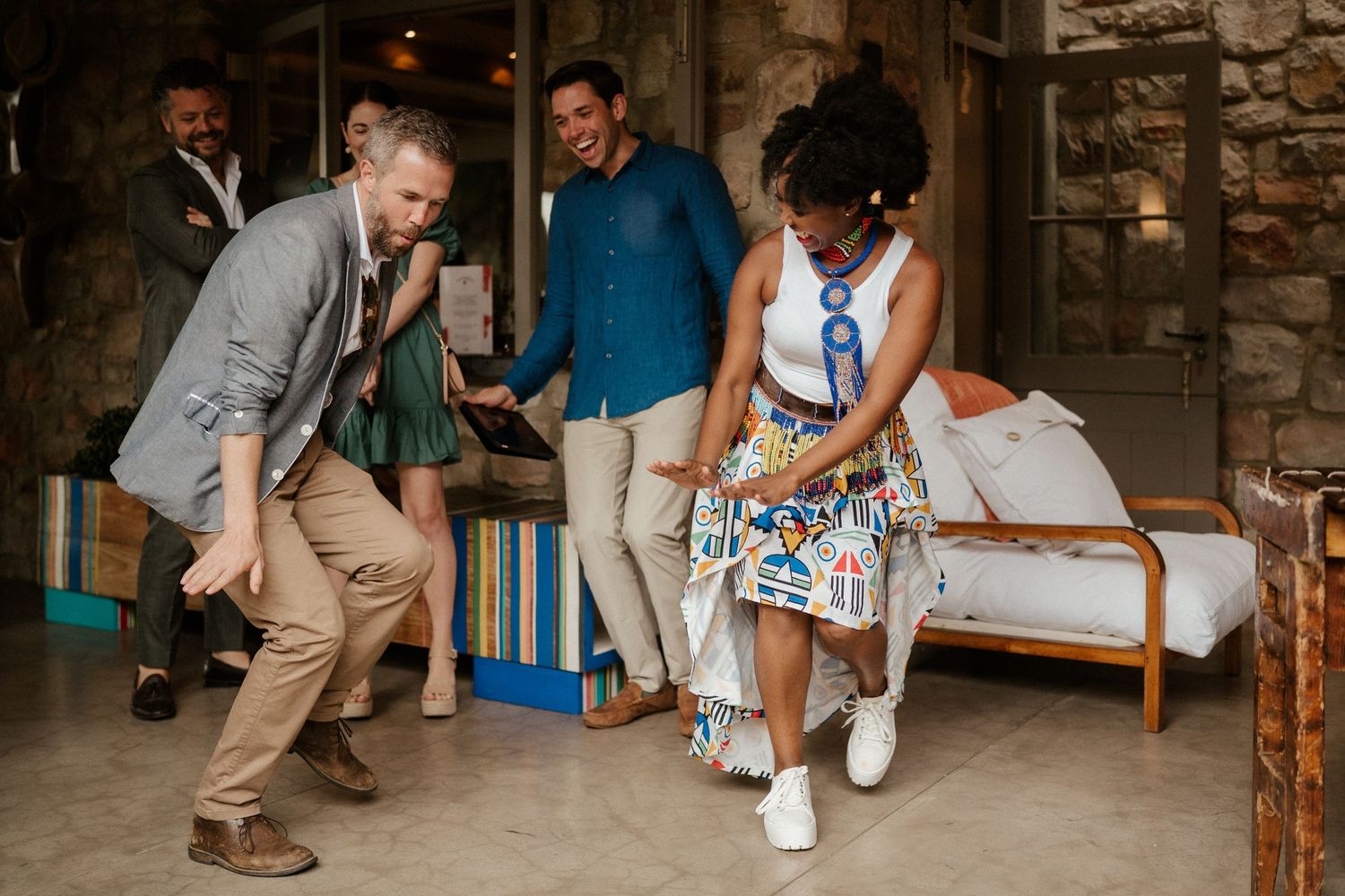 Dancing guests enjoy themselves on a stone patio during a wedding reception.