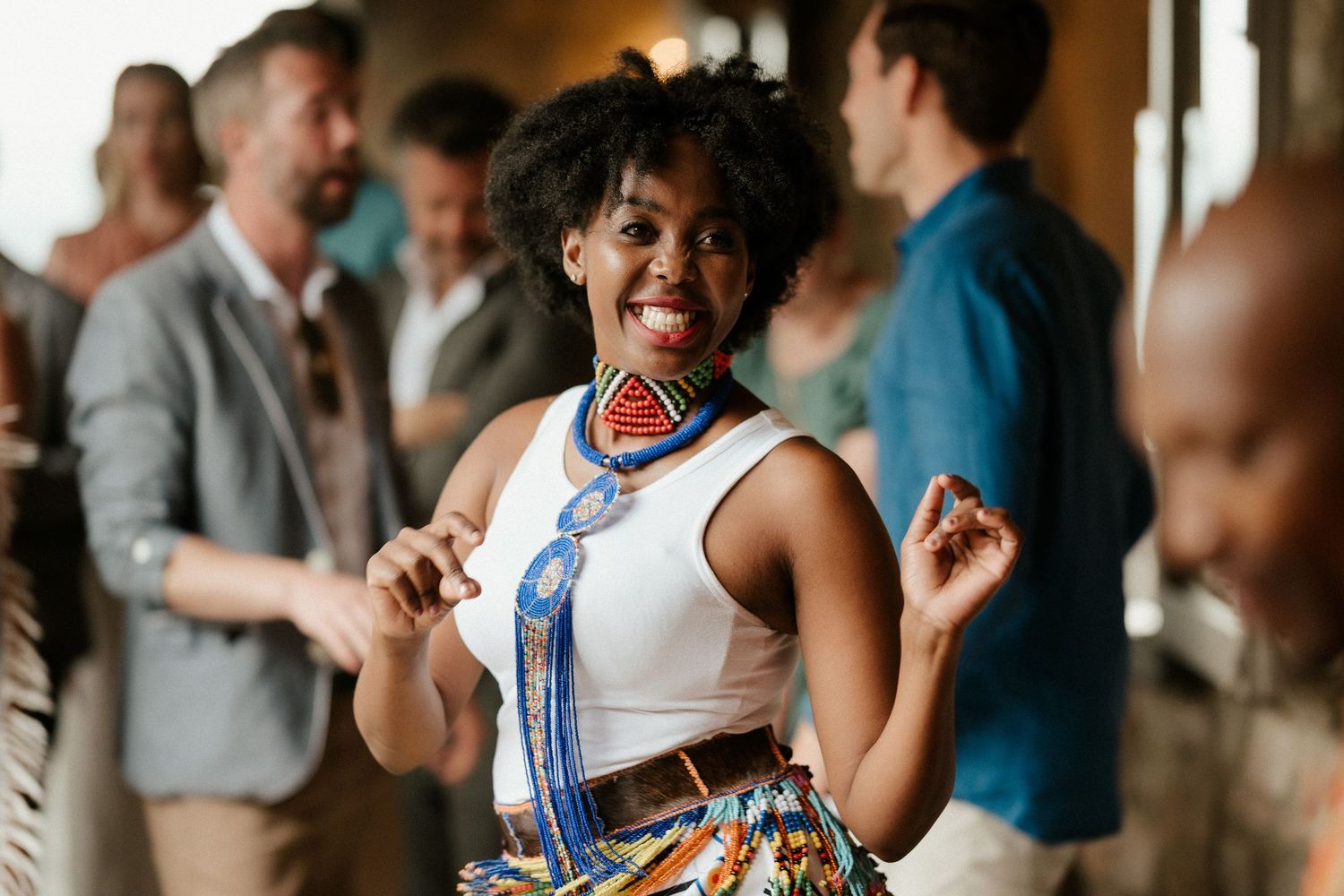 Guest dancing joyfully at celebration wearing colorful traditional African-inspired attire.