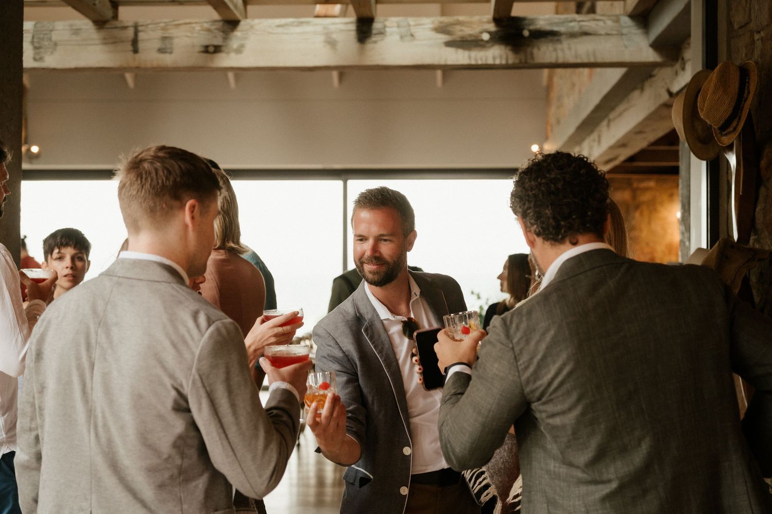 Small group enjoying drinks and conversation at an indoor gathering.