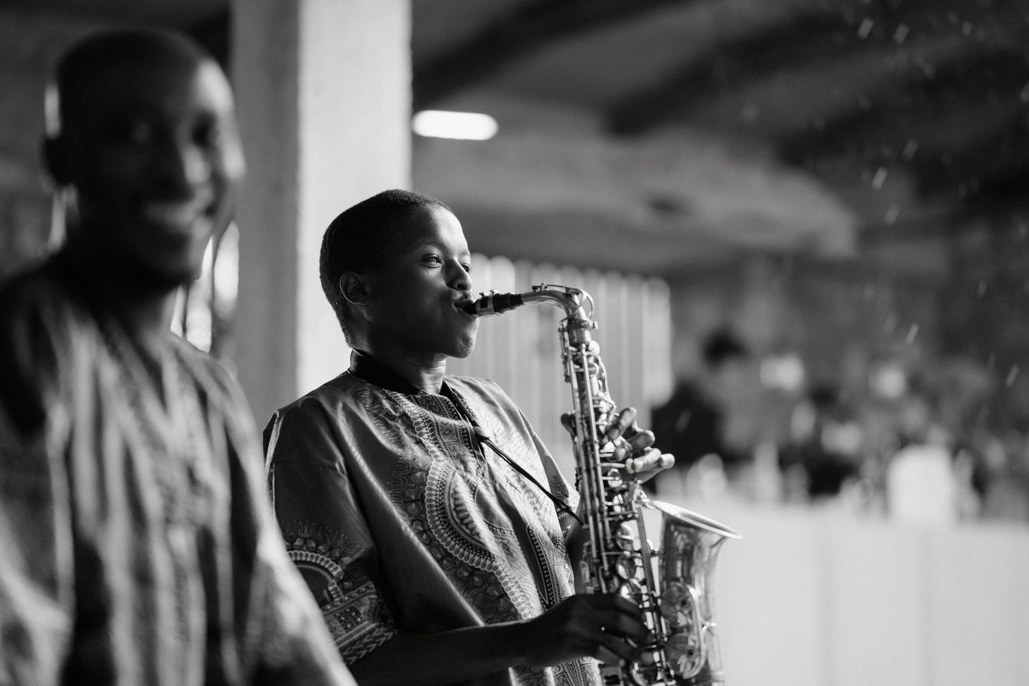 Black and white photograph of musicians performing with a saxophone at an event.