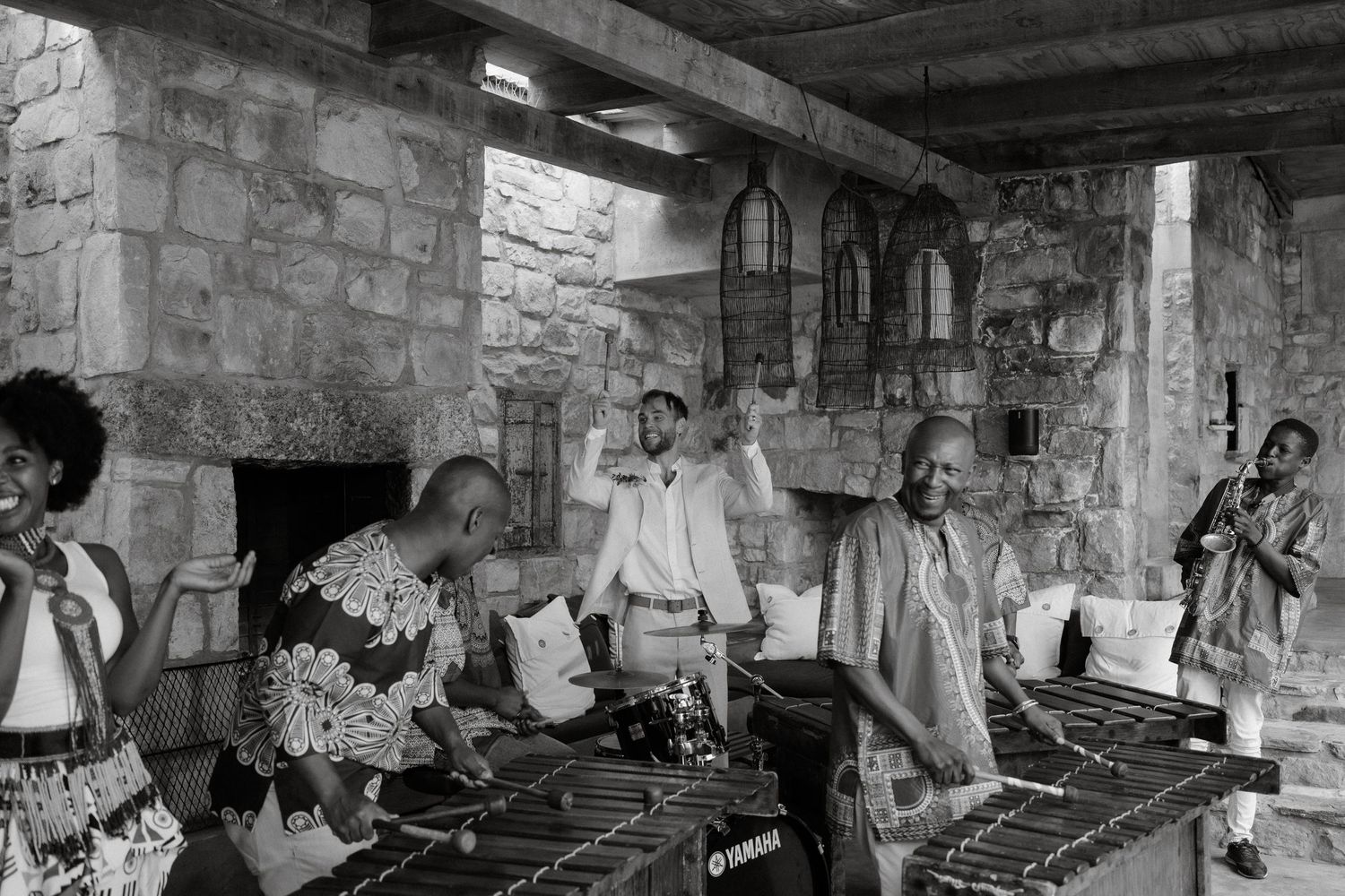 Vintage black and white photograph showing musicians playing marimbas in a stone interior.