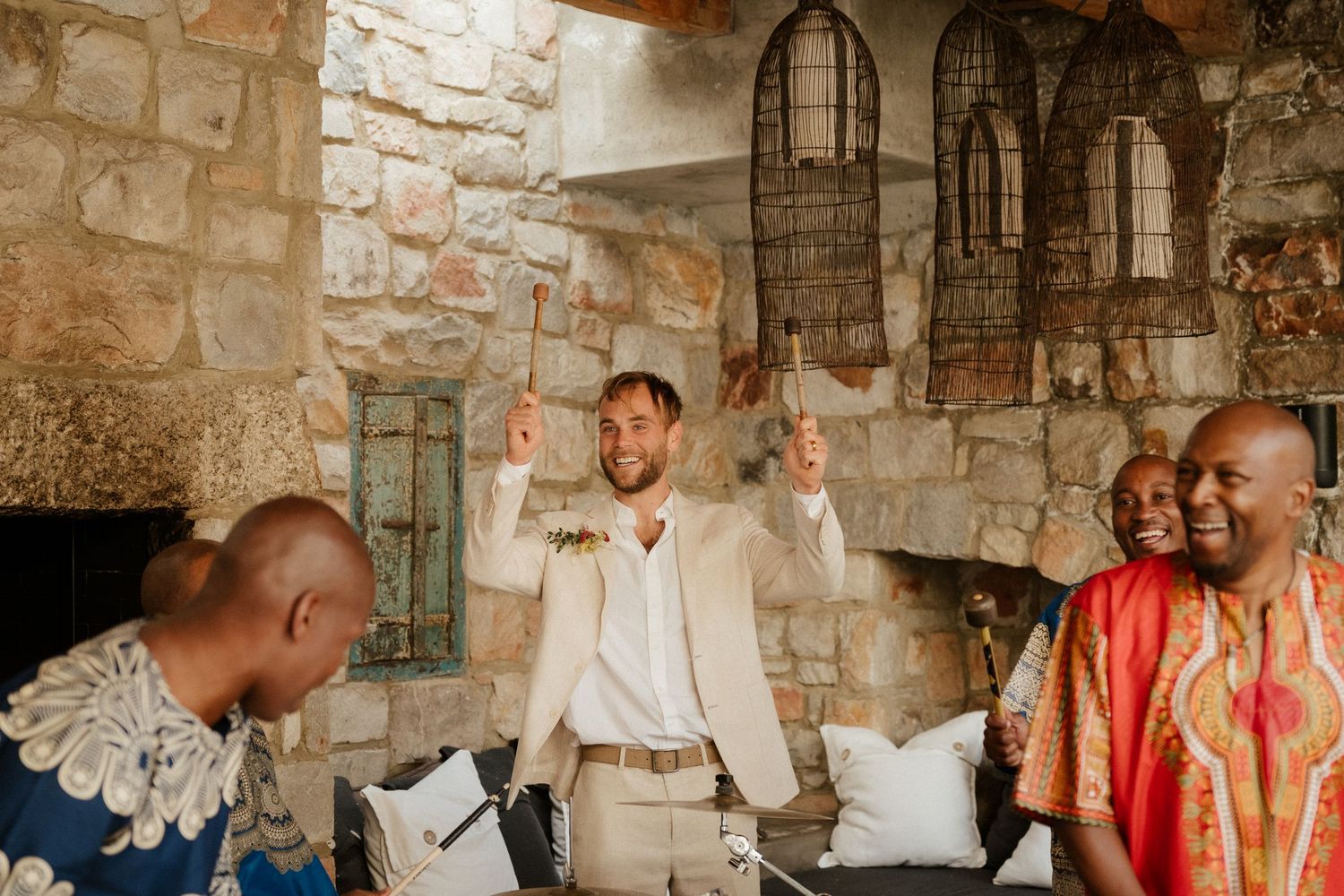 Joyful celebration at a rustic stone venue with decorative lanterns.