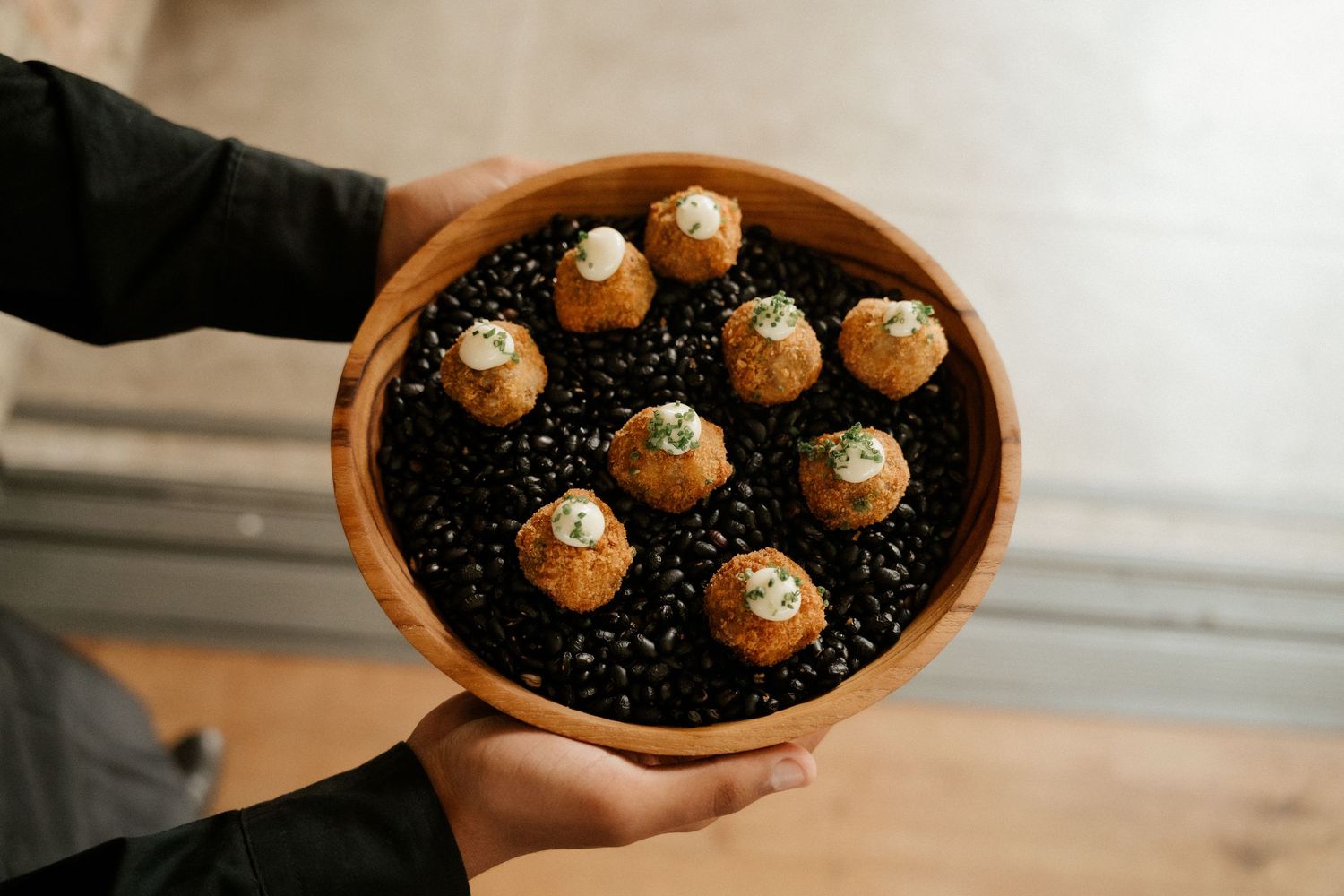 Elegant dessert platter featuring mini cupcakes arranged on black decorative surface.