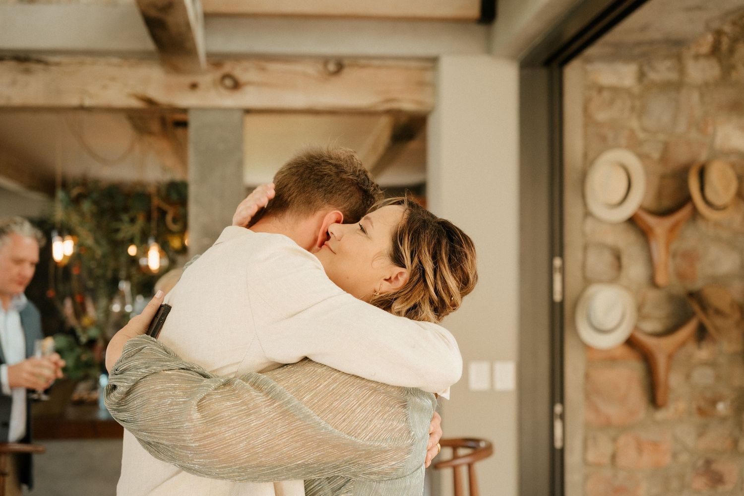 A romantic embrace shared in a rustic indoor setting with warm lighting.