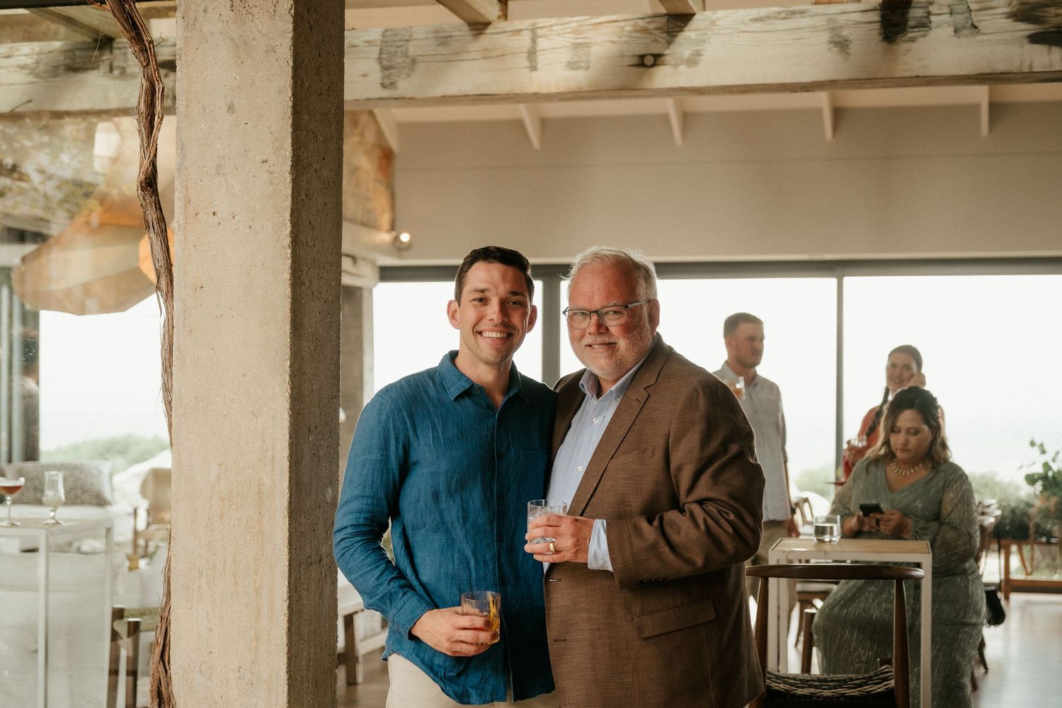 Guests enjoying drinks and conversation at an upscale indoor venue.