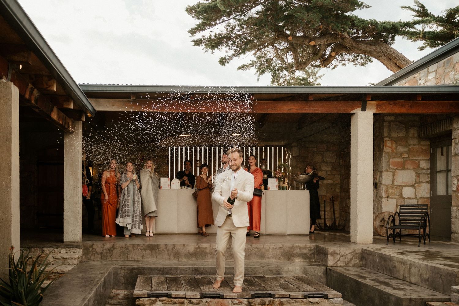 A celebratory moment with water splashing around a person in white against a rustic venue backdrop.