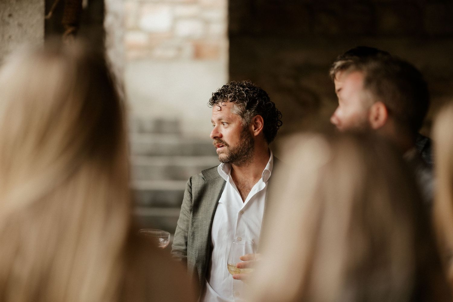 Atmospheric candid moment captured during reception in rustic stone venue.