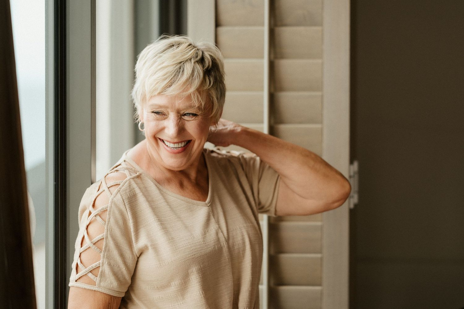 A candid moment of joy and laughter near a window with natural light.
