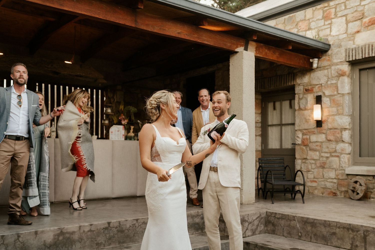 A wedding ceremony taking place on a stone patio with guests gathered around.
