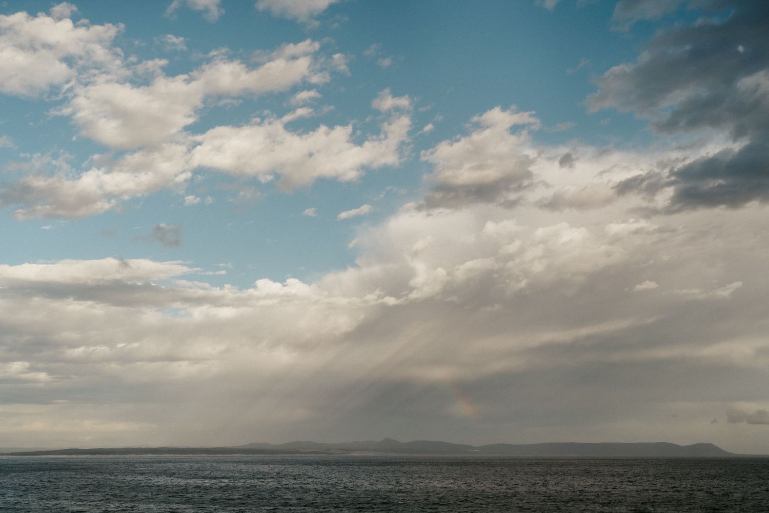 Dramatic seascape with fluffy clouds and ocean views during golden hour.