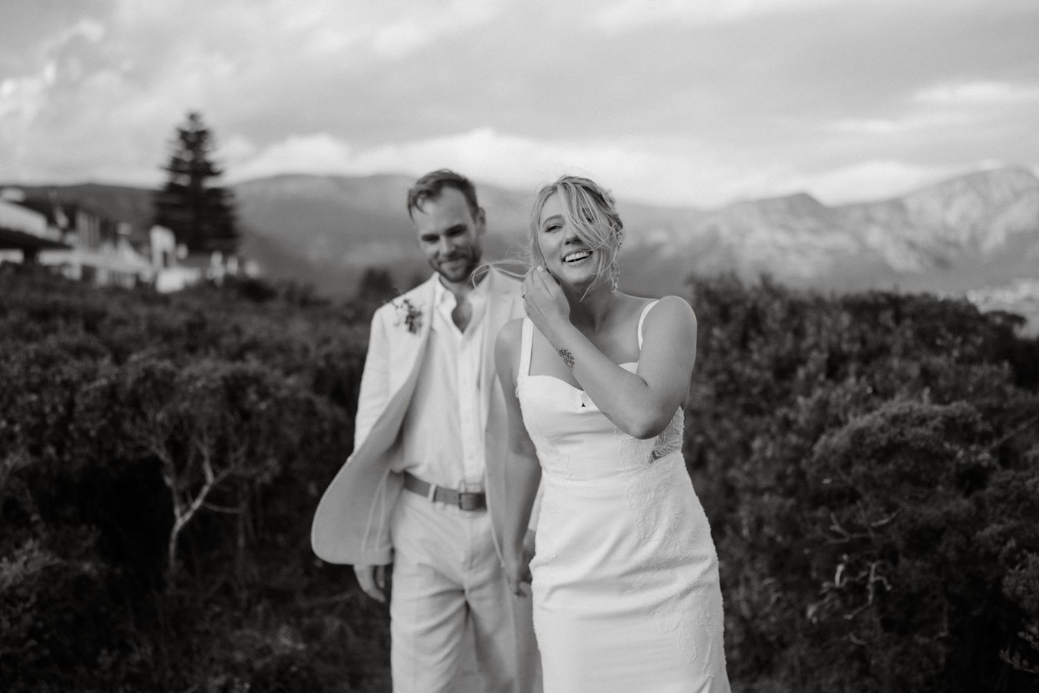 A couple shares a candid moment together against a backdrop of scenic mountains.