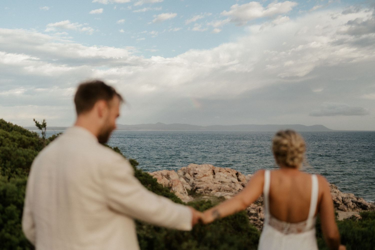 A scenic coastal moment against a backdrop of blue water and mountains.