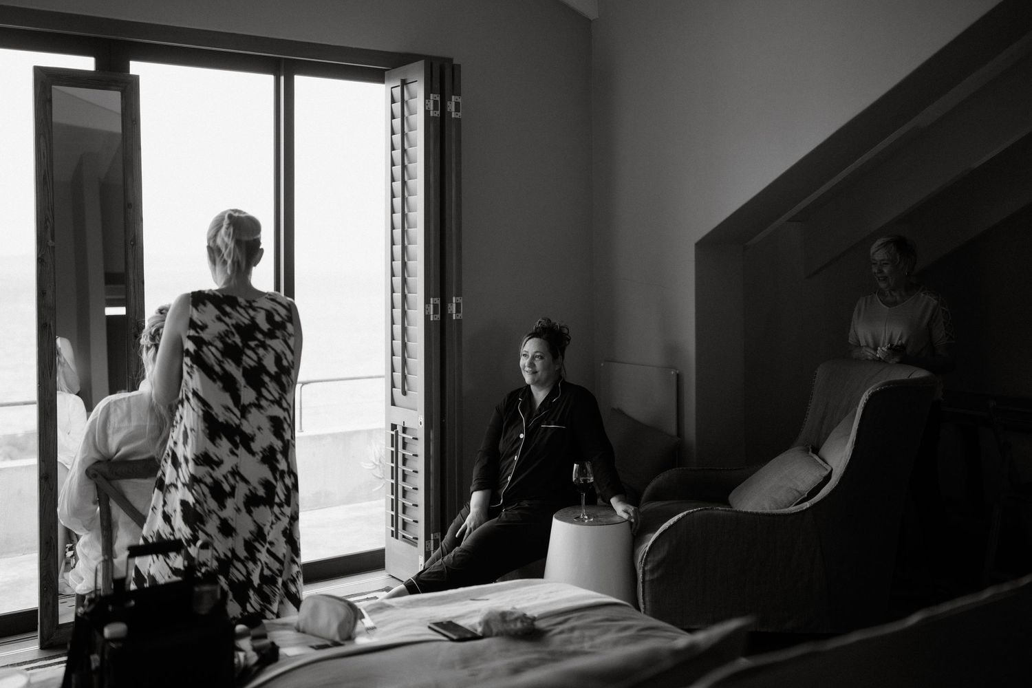 Black and white photo of wedding preparations in a bright room with window light.