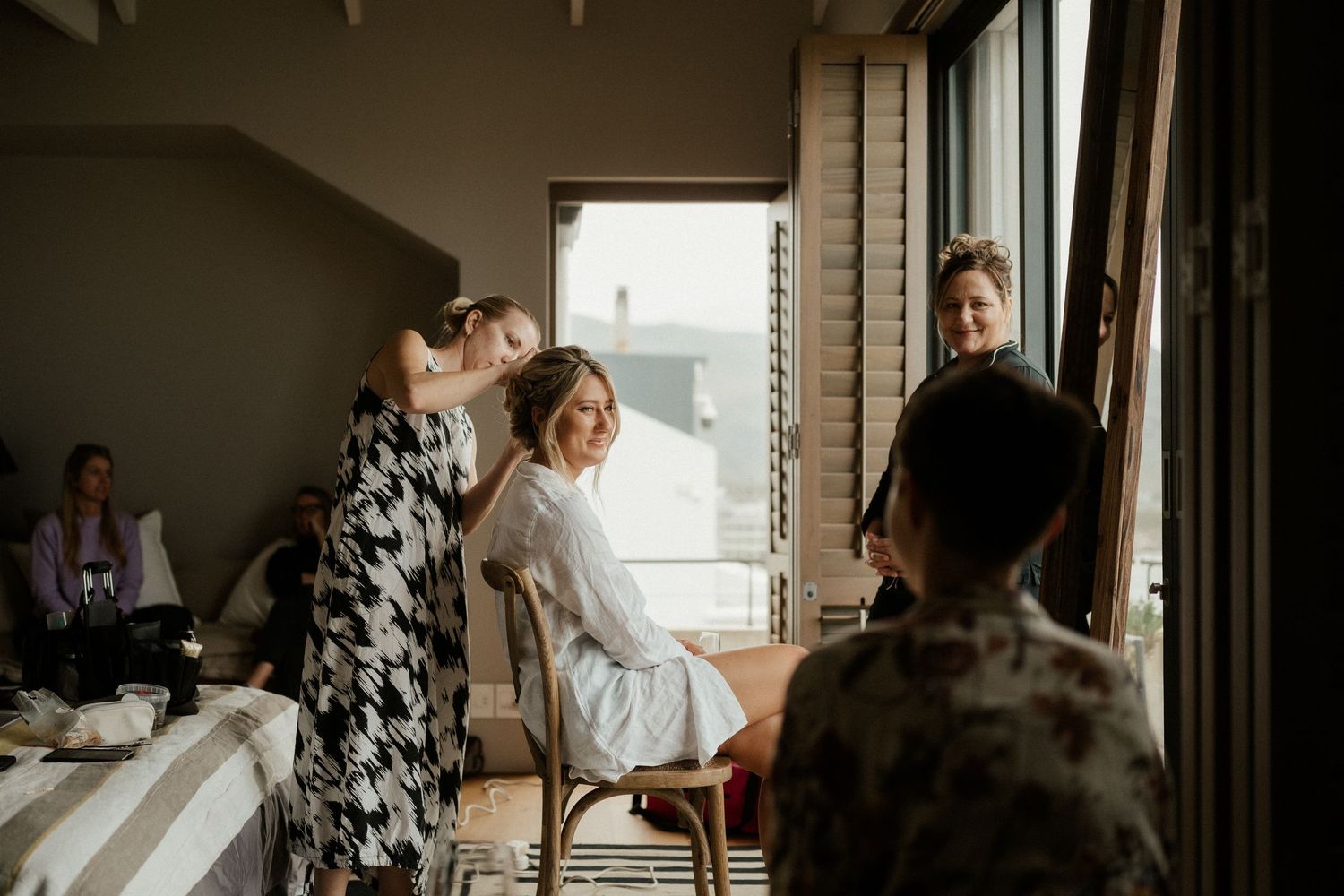Wedding preparation scene by a window with natural daylight streaming in.