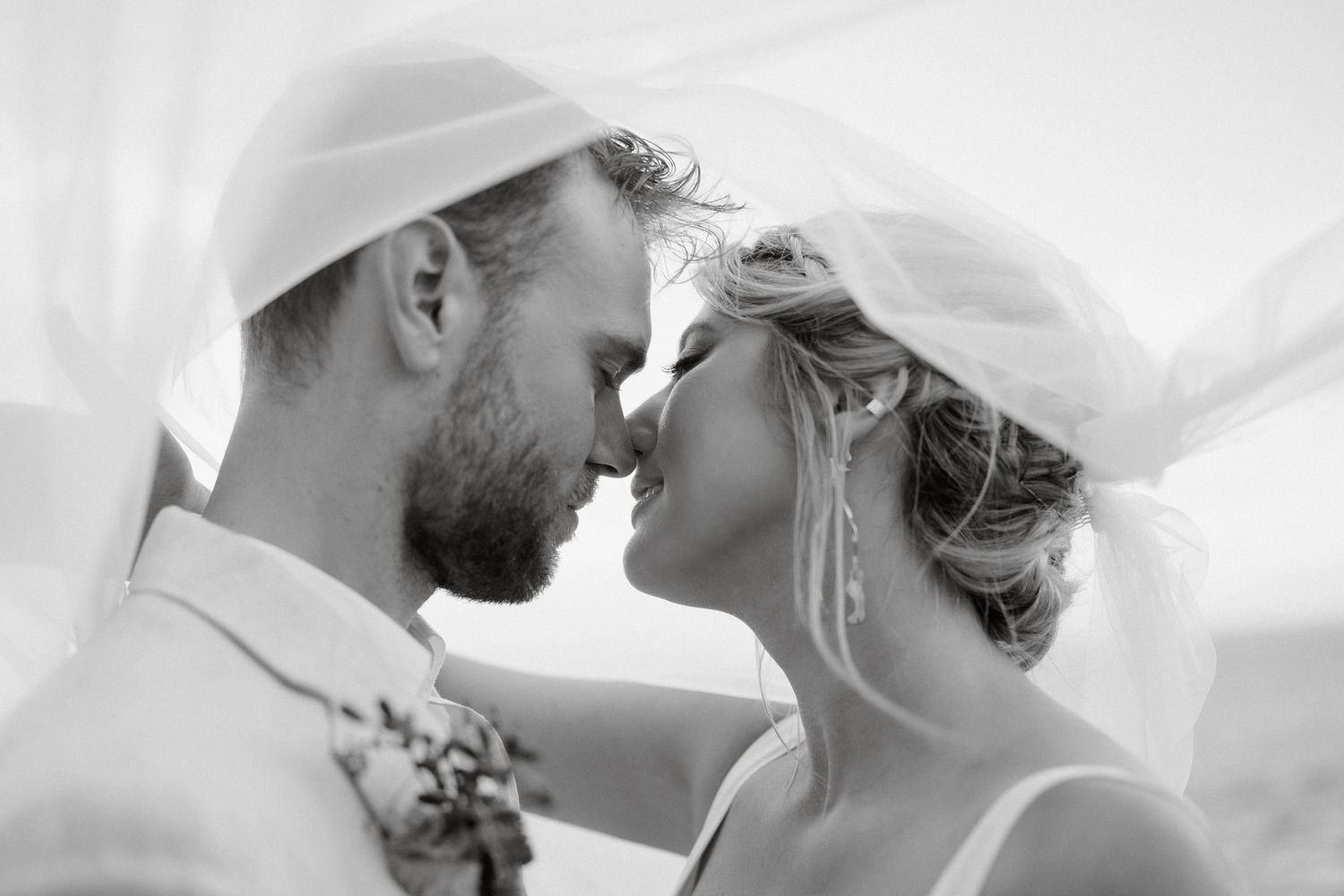 Intimate black and white wedding moment captured in soft natural light.