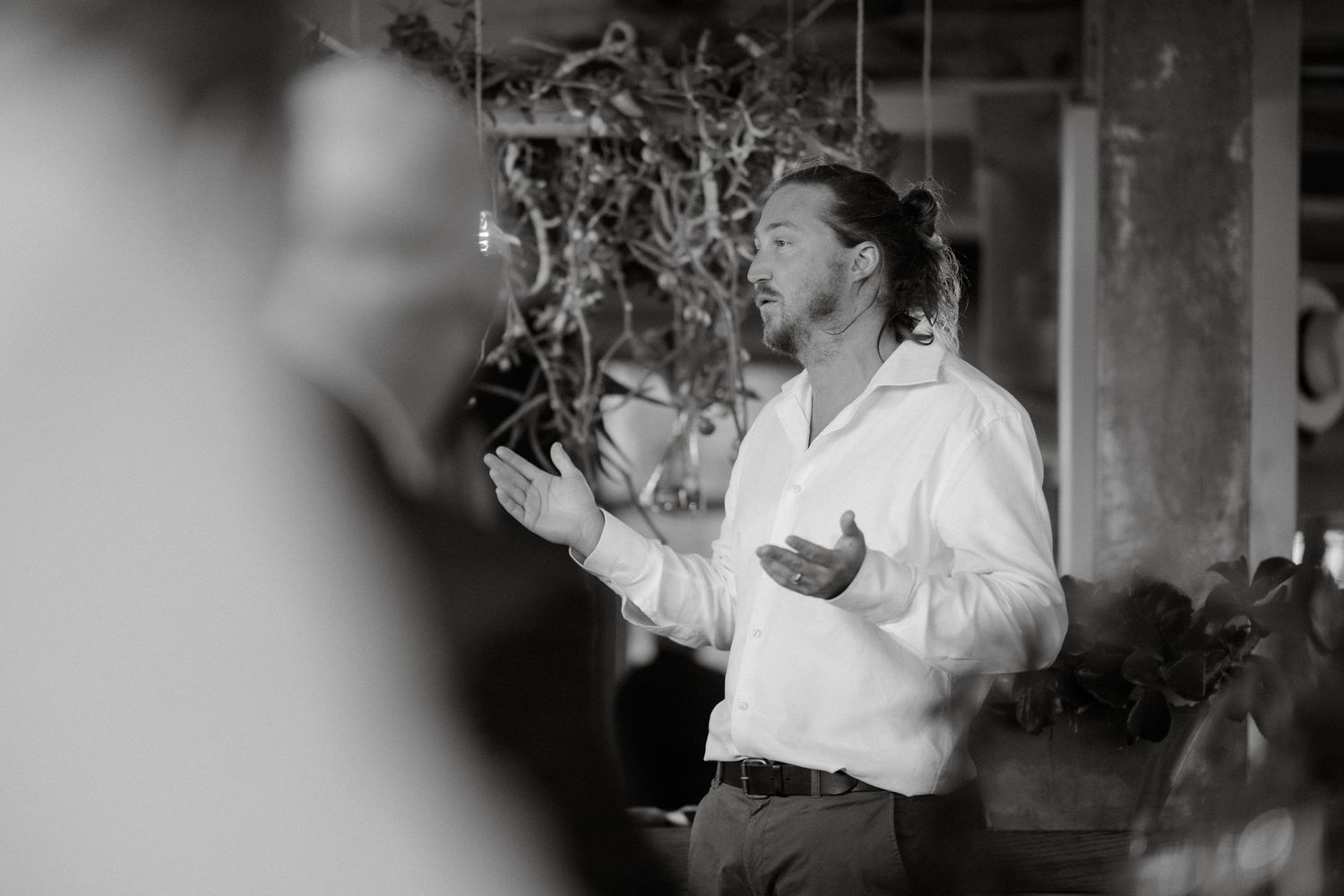 Black and white candid of person giving emotional wedding speech at reception.